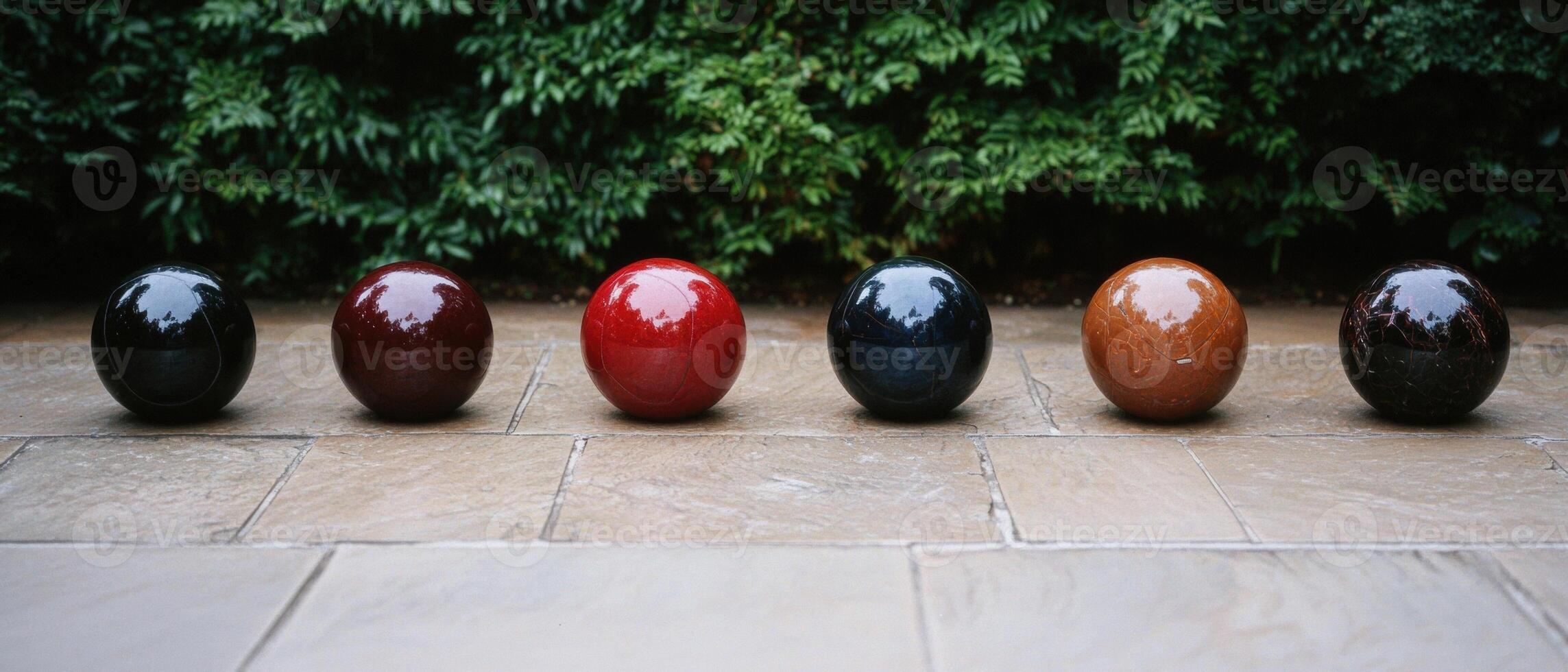 A row of colorful bocce balls on a stone surface photo
