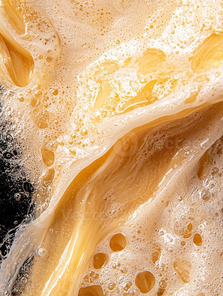 Close up of a frothy, golden liquid with bubbles photo