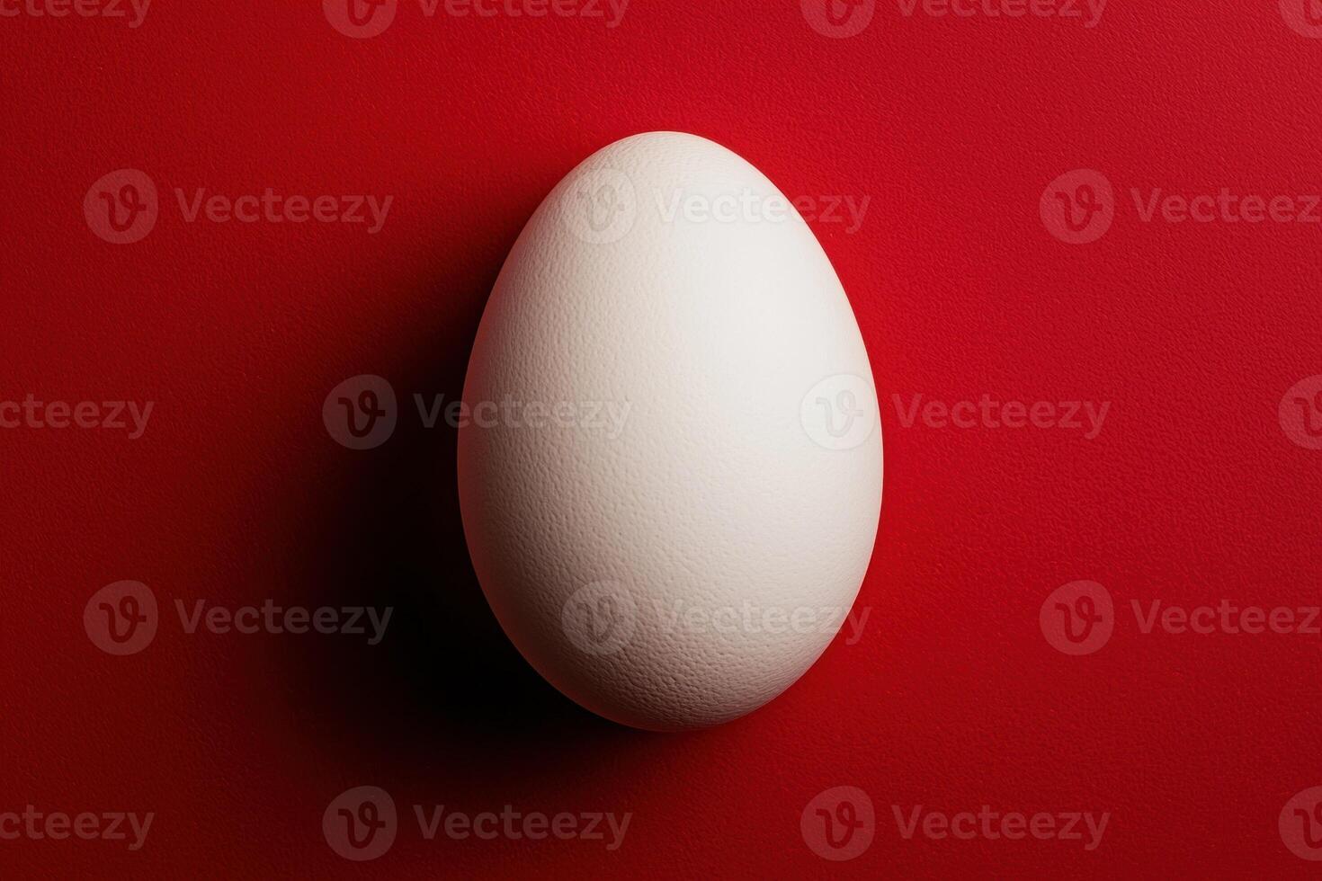 Single white egg on a red textured background photo