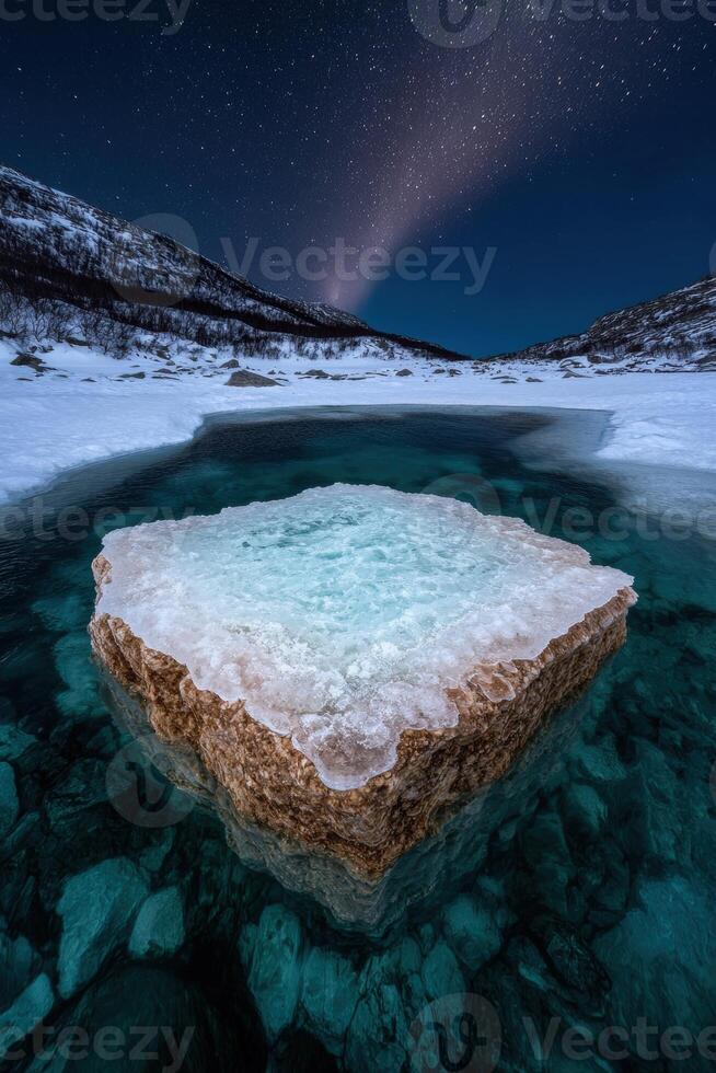 A frozen rock formation in a winter landscape under the night sky photo