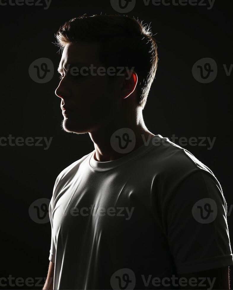 Profile of a Young Man in Silhouette Against Dark Background photo