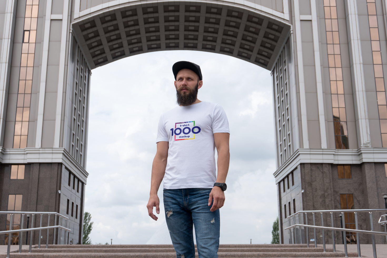 Confident Man with Beard Wearing Branded T-Shirt Stands Under Modern Archway psd