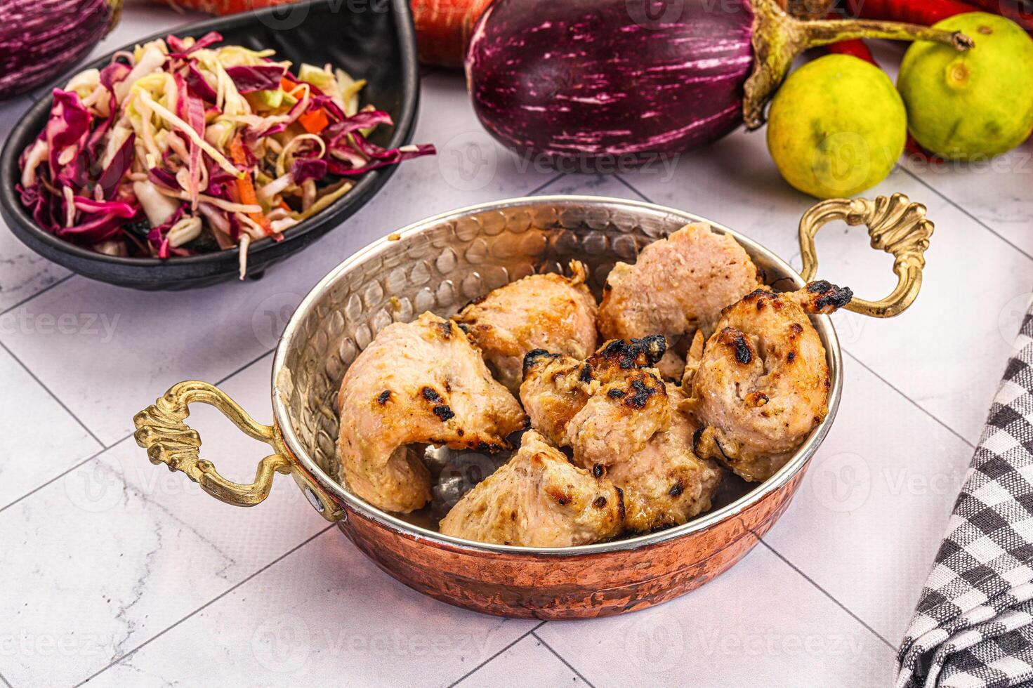 A bowl of chicken and vegetables on a table photo