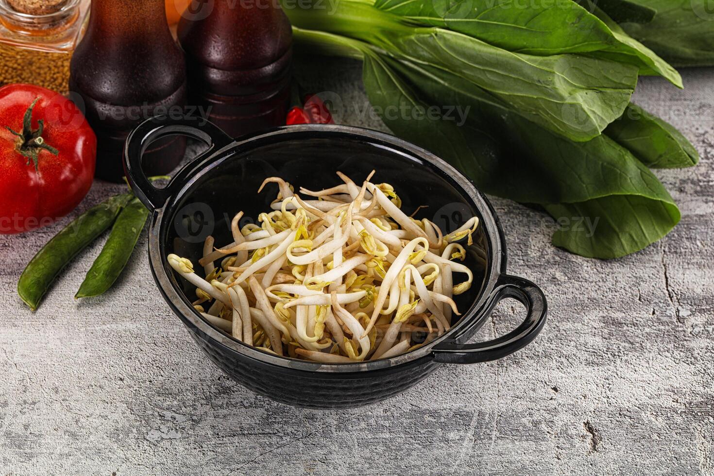 A bowl of vegetables and a bottle of sauce photo
