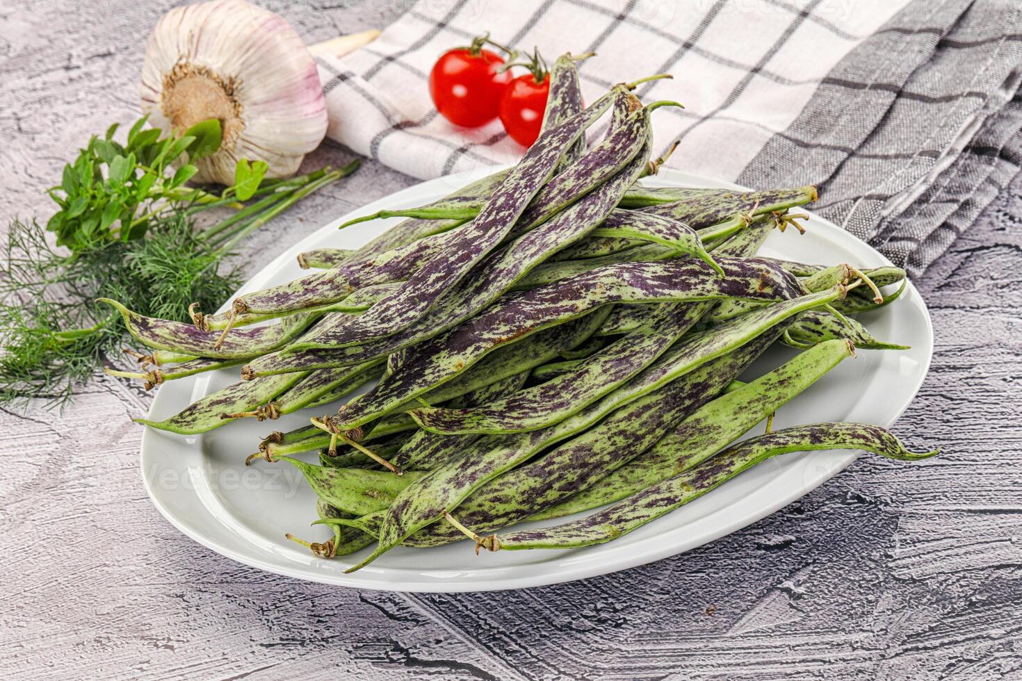 A plate of beans and vegetables on a table photo