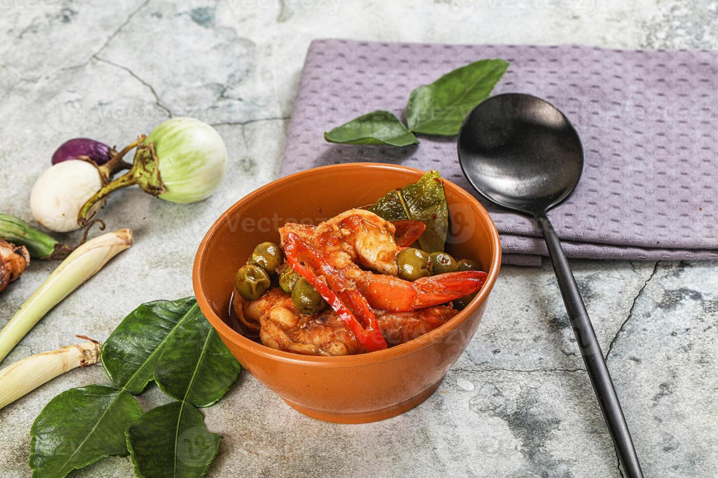 A bowl of food with vegetables and a spoon photo