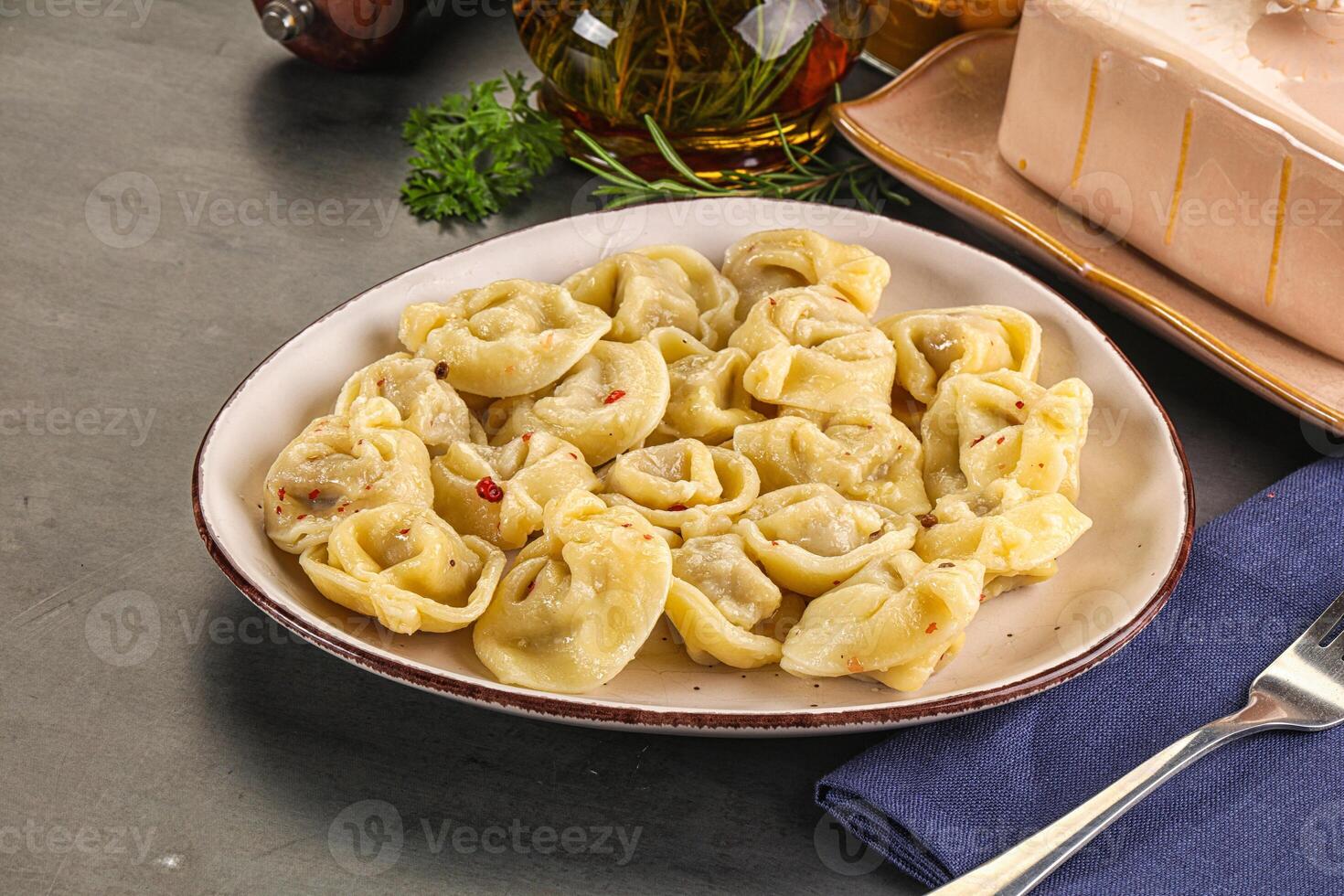 A plate of pasta with a fork and knife on a table photo
