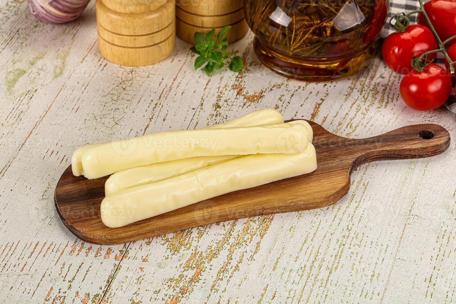 A wooden cutting board with cheese and other ingredients photo