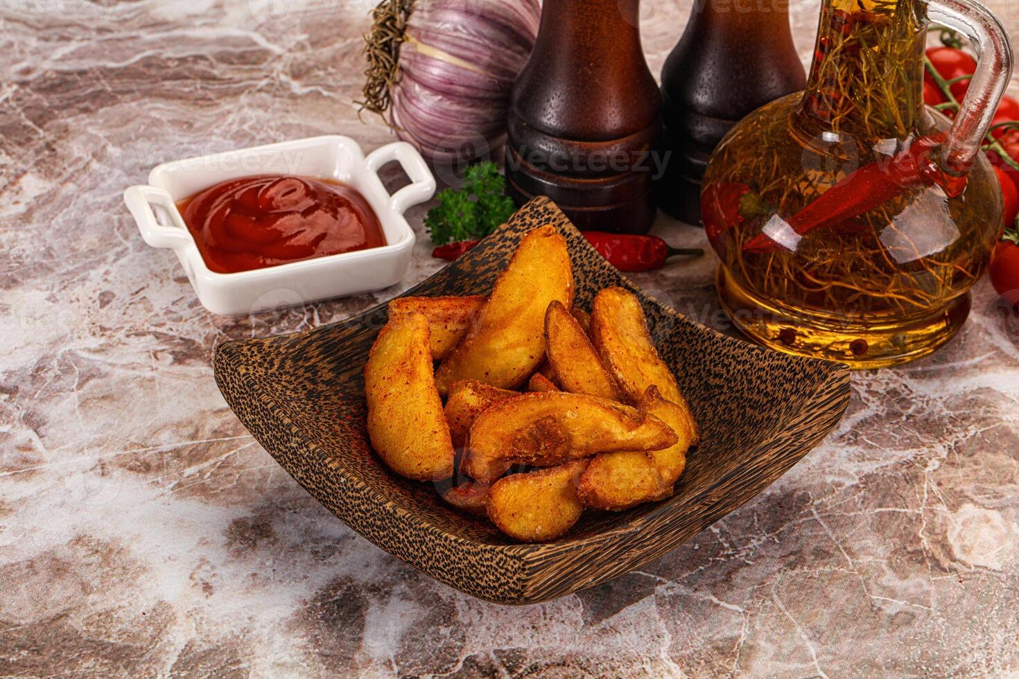 A bowl of french fries and a bottle of ketchup photo