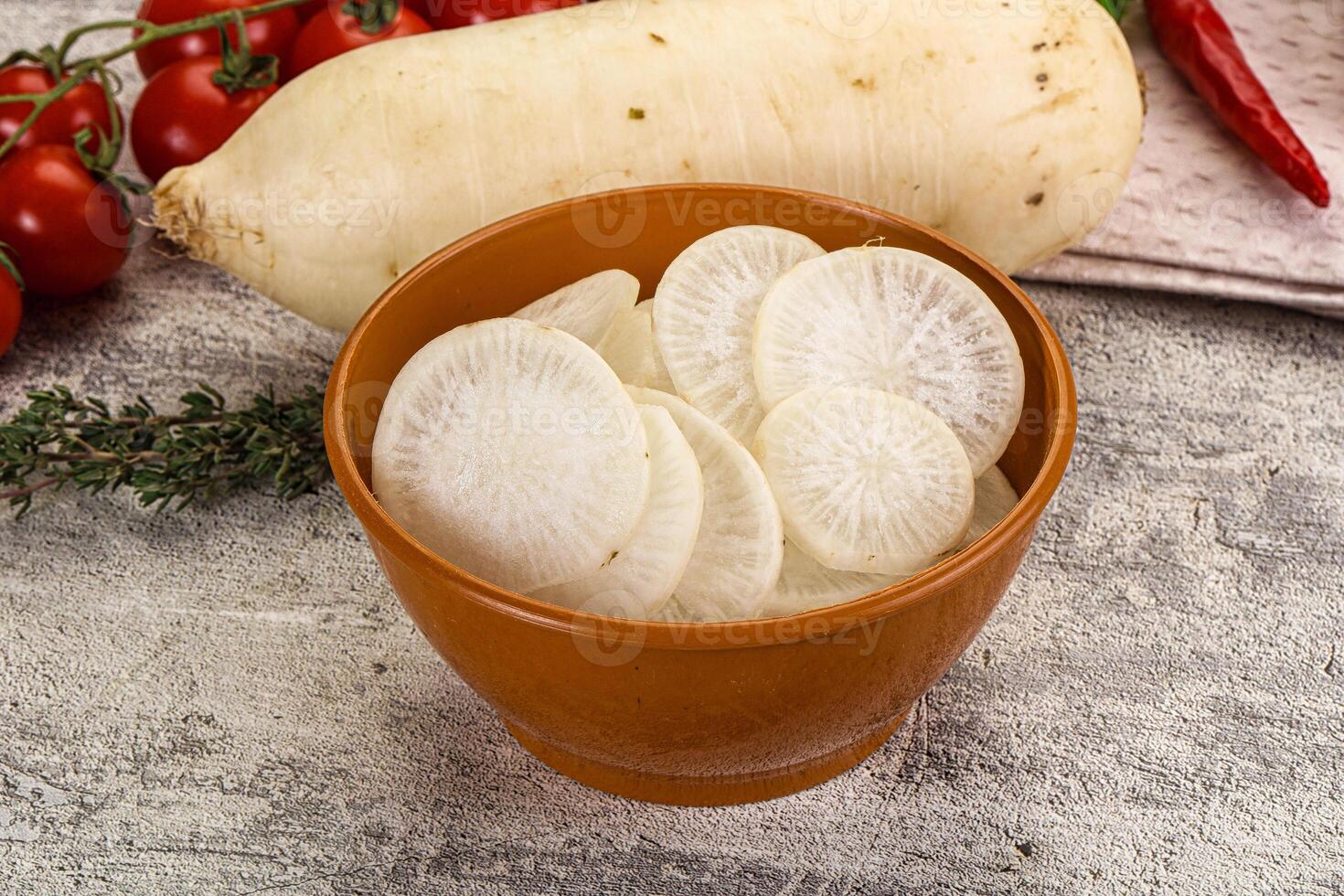 A bowl of sliced potatoes and vegetables on a table photo