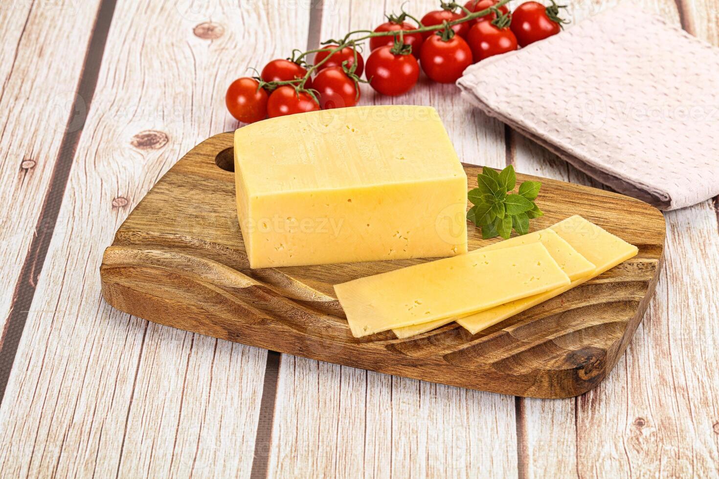 A piece of cheese on a wooden cutting board photo