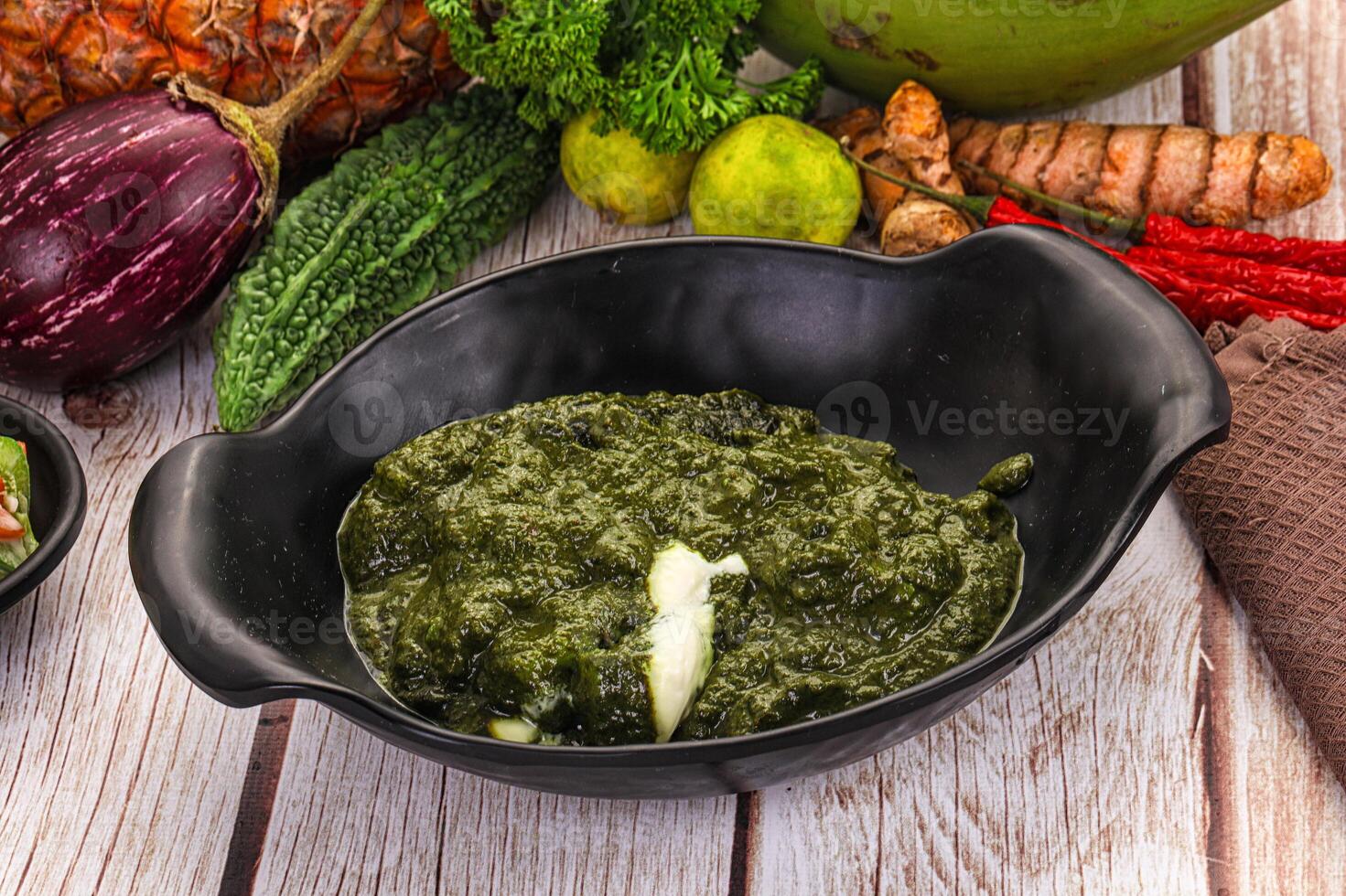 A bowl of green food sitting on a table photo