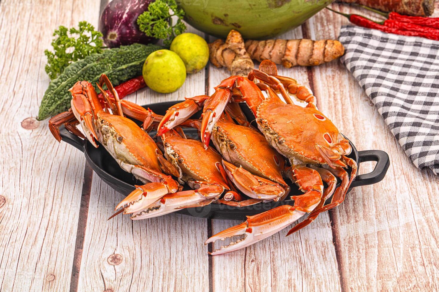 A bunch of crabs sitting on a plate with some vegetables photo