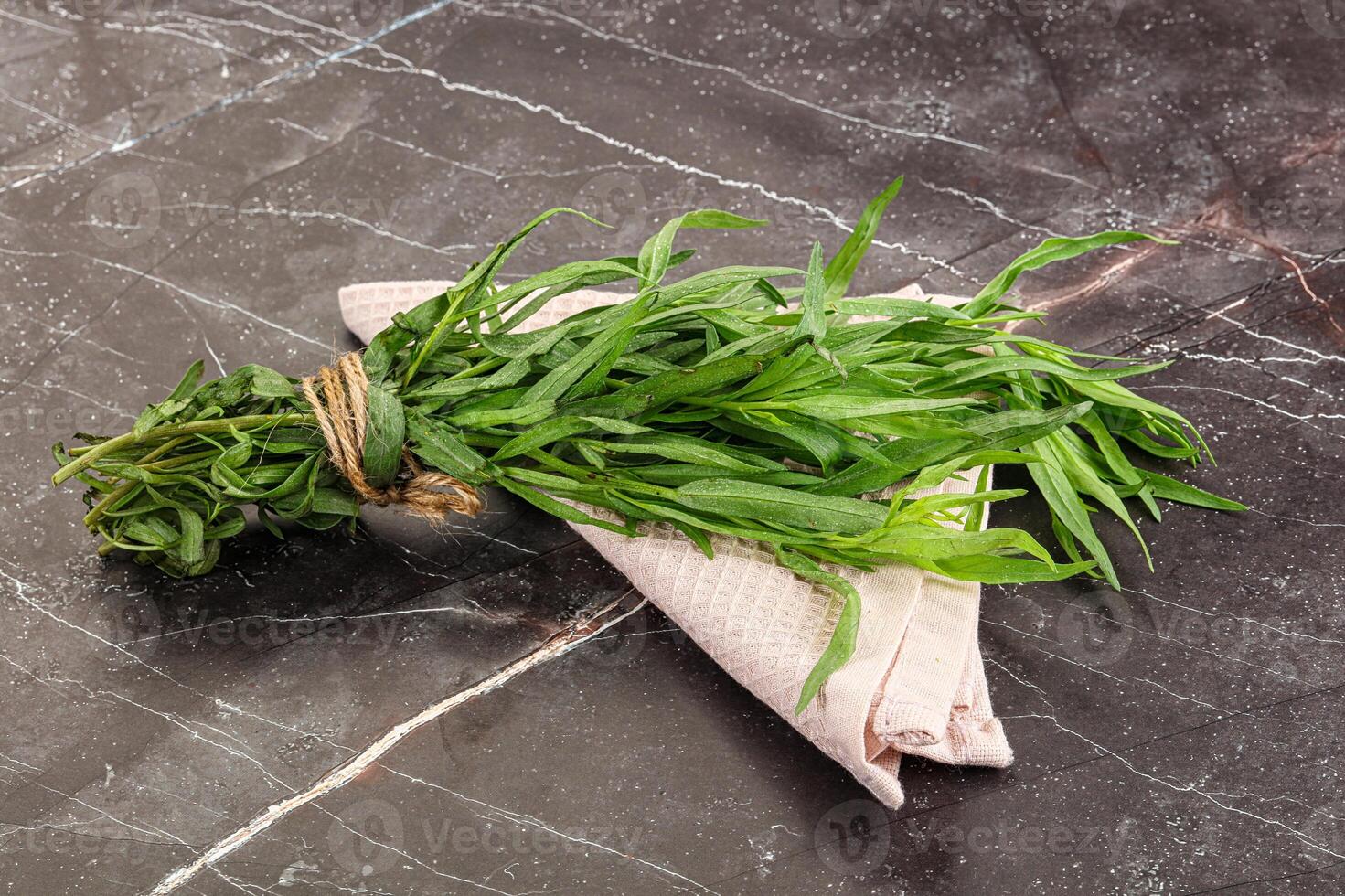 A bunch of fresh herbs on a marble surface photo