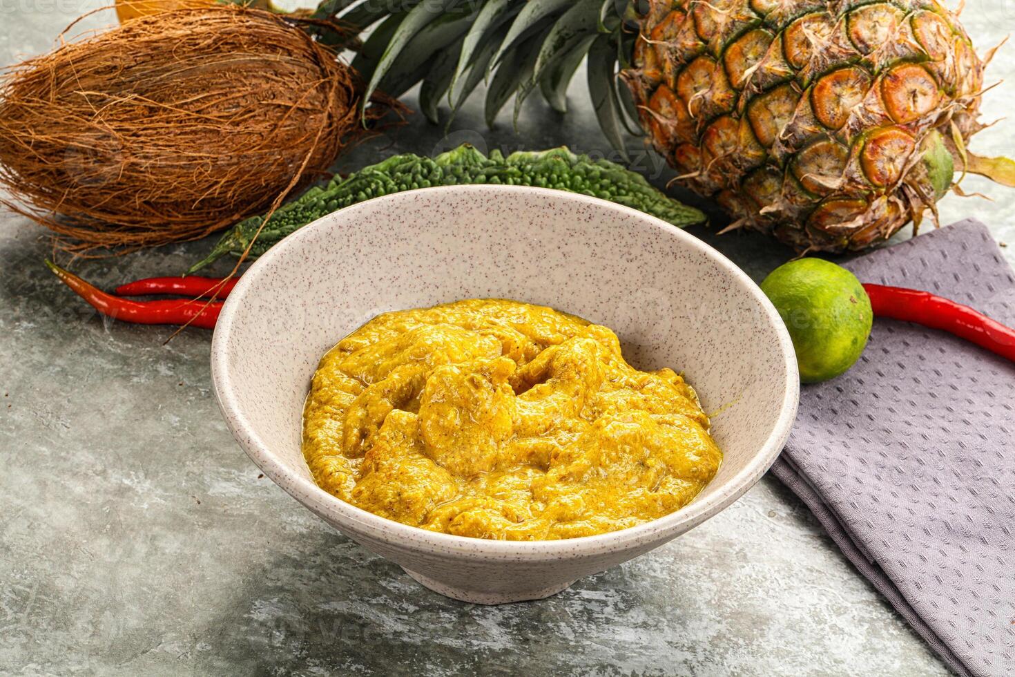 A bowl of pineapple sauce next to a pineapple photo