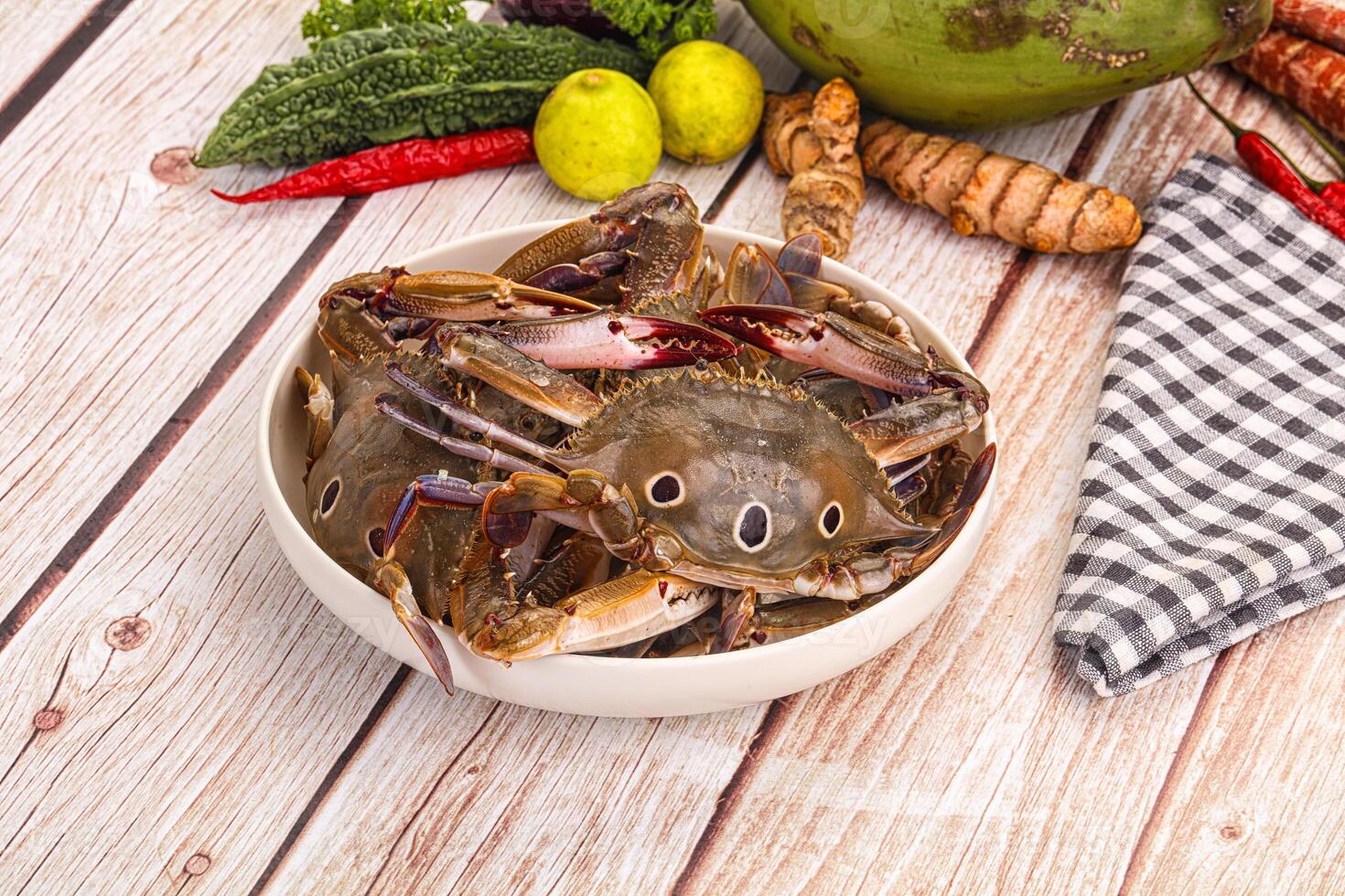 A bowl of crabs and other vegetables on a table photo