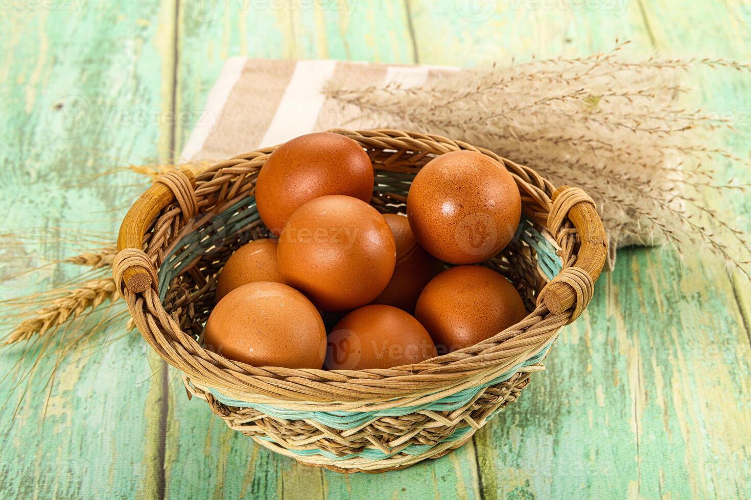 Brown eggs in basket on wooden table photo