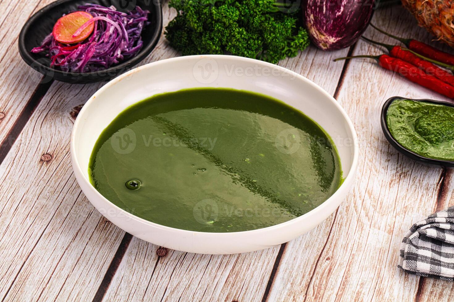 A bowl of green soup on a table photo