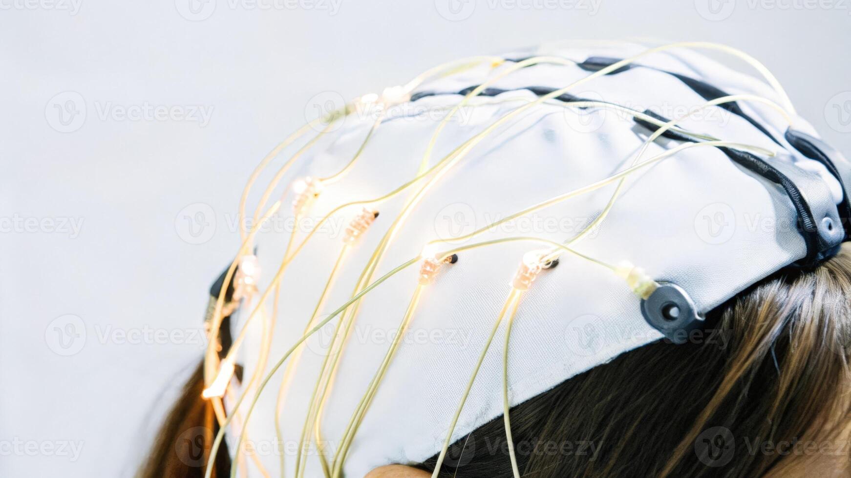 Detailed view of a braincomputer interface headset featuring glowing electrodes that are delicately p on the scalp conveying energy and data transfer through vibrant color. photo