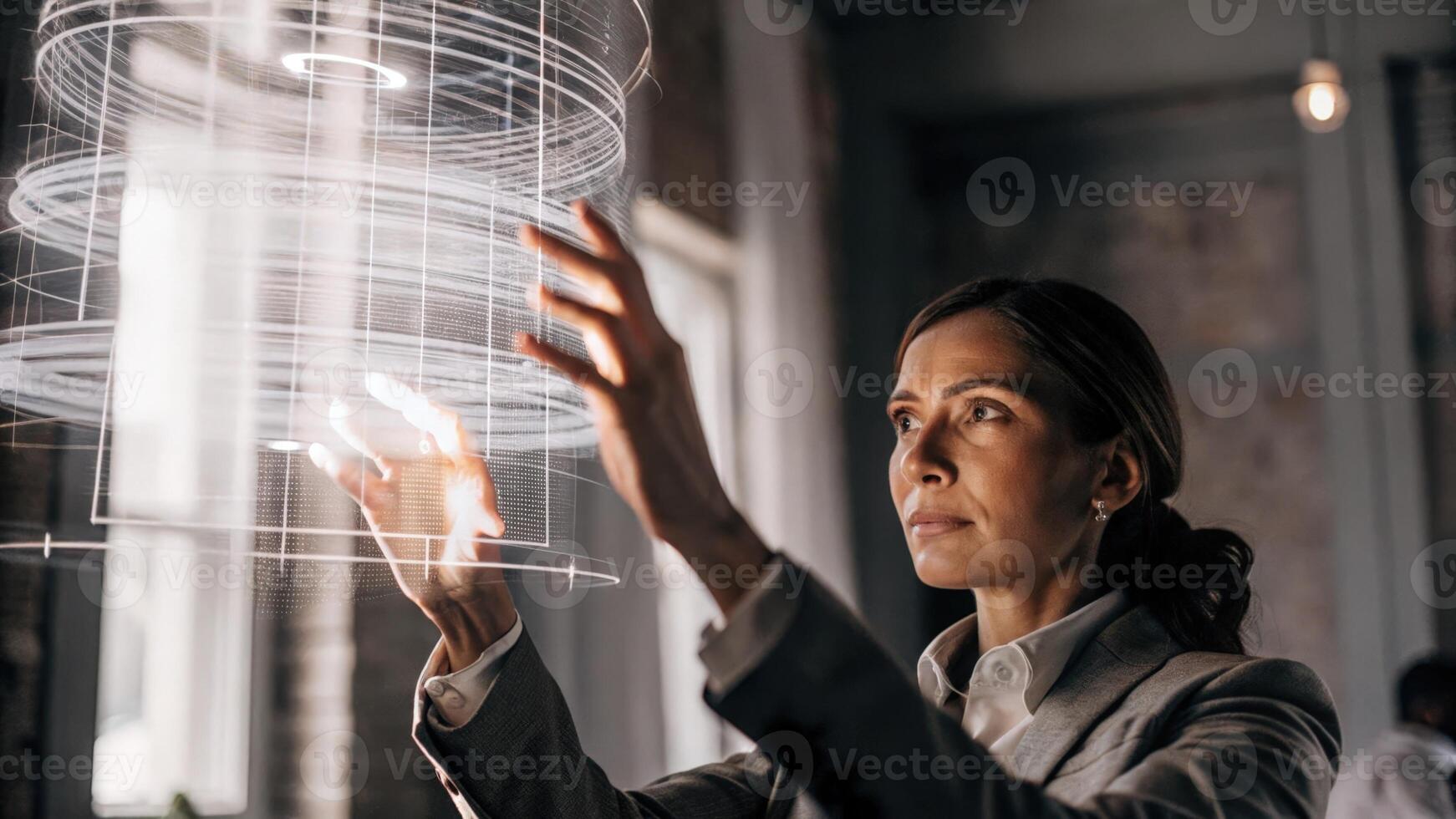 A focused businesswoman using hand gestures to manipulate a holographic presentation revealing intricate details layered within the projected data.. photo