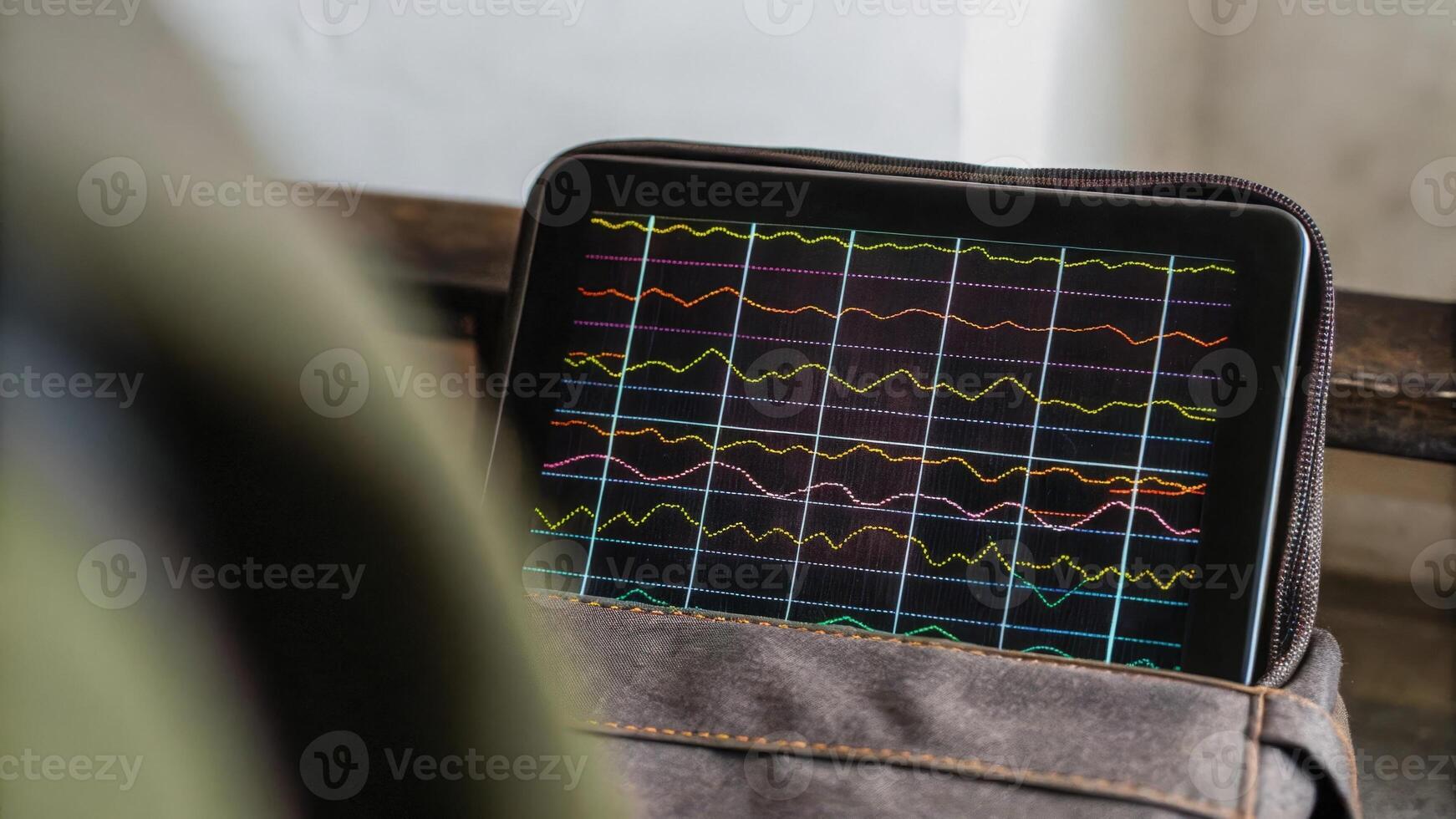 Closeup of a digital display reflecting brainwave activity with colorful graphs and dynamic waveforms indicating realtime neural responses during stimulation.. photo