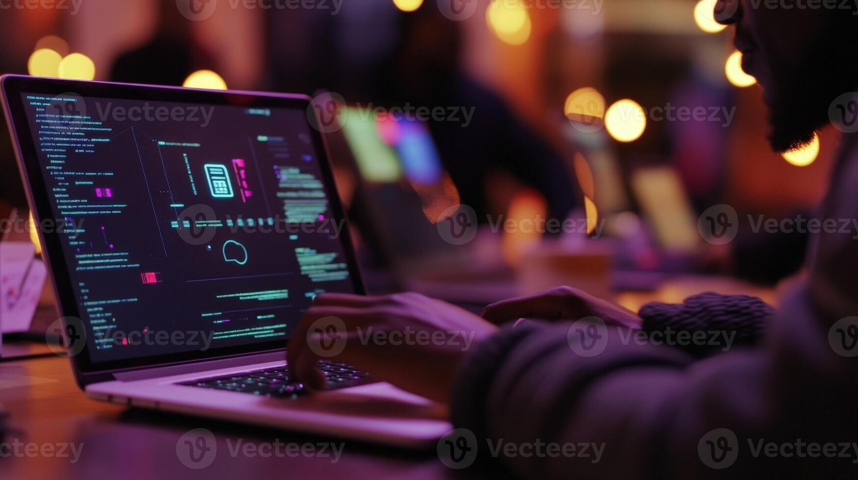 A closeup of a participants hands typing on a laptop during a cybersecurity workshop with a bright monitor showcasing a diagram of a firewall and network security protocols. Posti photo