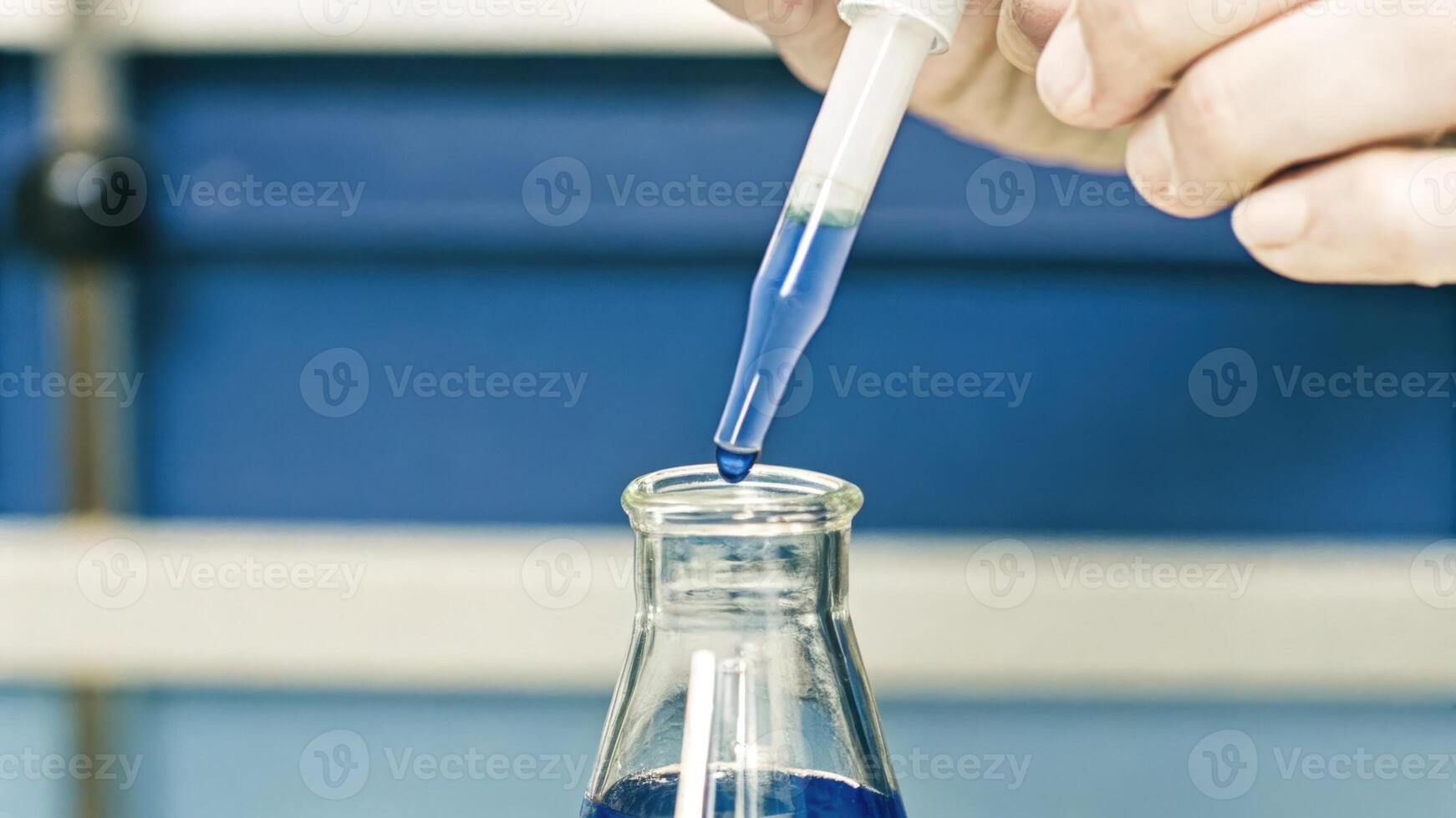 A closeup shot of a scientists hands carefully pipetting a bright blue dye into a flask showcasing the precise technique required in cell culture techniques.. photo