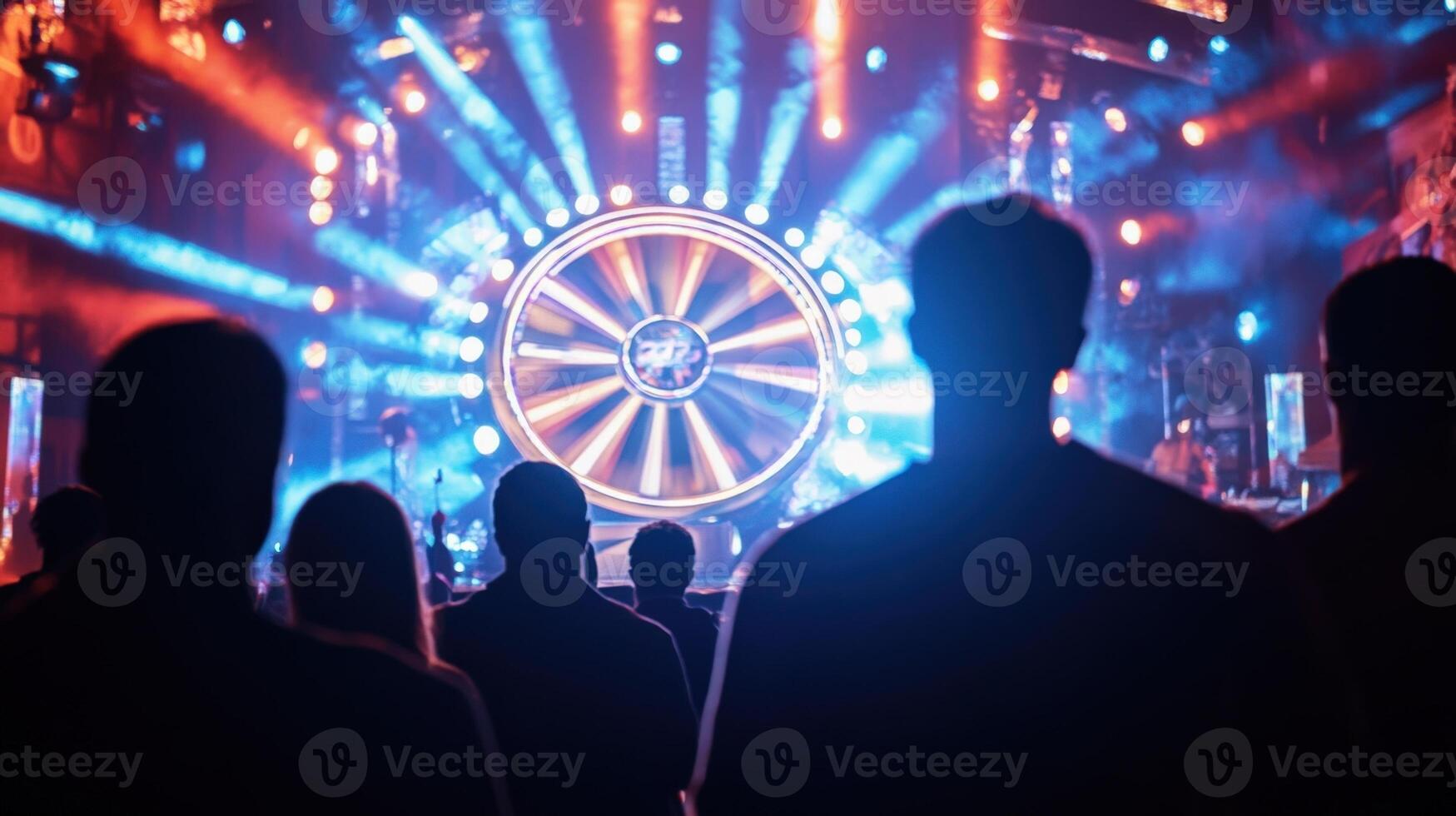 A moment of suspense as a contestant prepares to spin a giant prize wheel surrounded by flashing lights and dramatic sound effects with the host encouraging them while the audienc photo