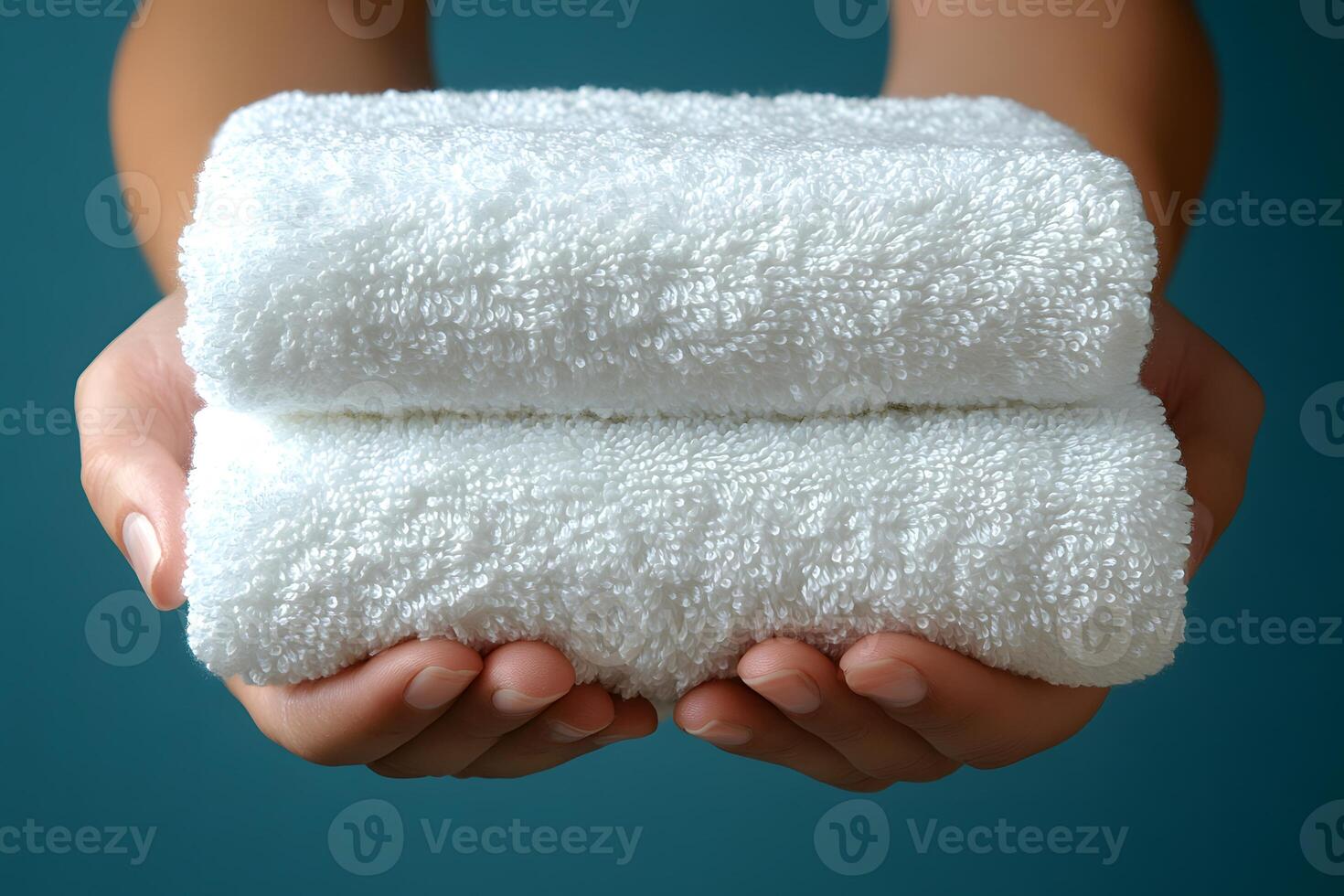 Freshly Folded White Towels in Hands for Spa and Wellness Settings photo