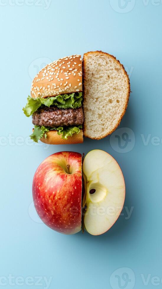 Creative concept of a burger and an apple halved on a blue background photo