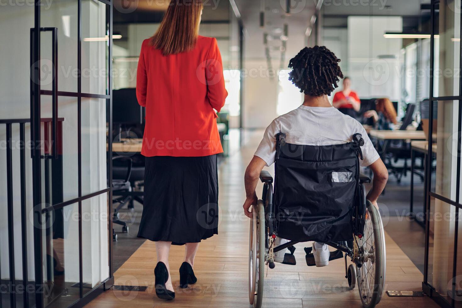 A group of young business people in a modern glass-walled office captures the essence of diversity and collaboration, while two colleagues, including an African American businessman in a wheelchair photo