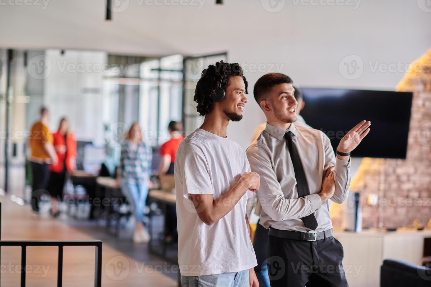 A group of colleagues, including an African American businessman and a young leader in a shirt and tie, pose together in a modern coworking center office, representing a dynamic blend of photo