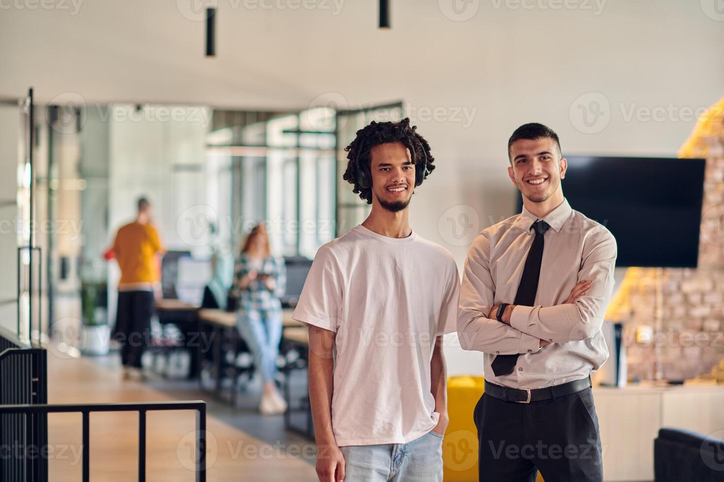 A group of colleagues, including an African American businessman and a young leader in a shirt and tie, pose together in a modern coworking center office, representing a dynamic blend of photo