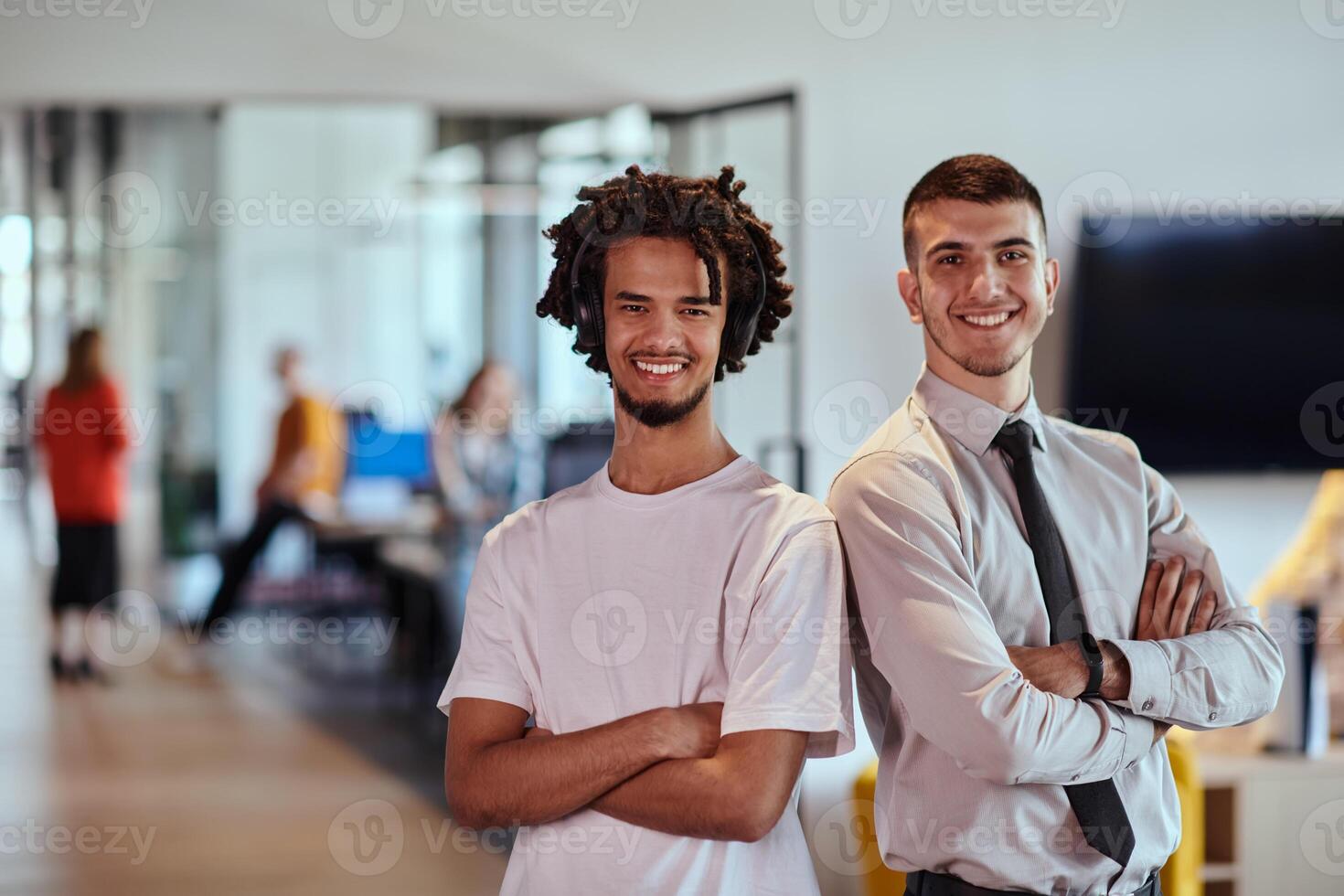 A group of colleagues, including an African American businessman and a young leader in a shirt and tie, pose together in a modern coworking center office, representing a dynamic blend of photo