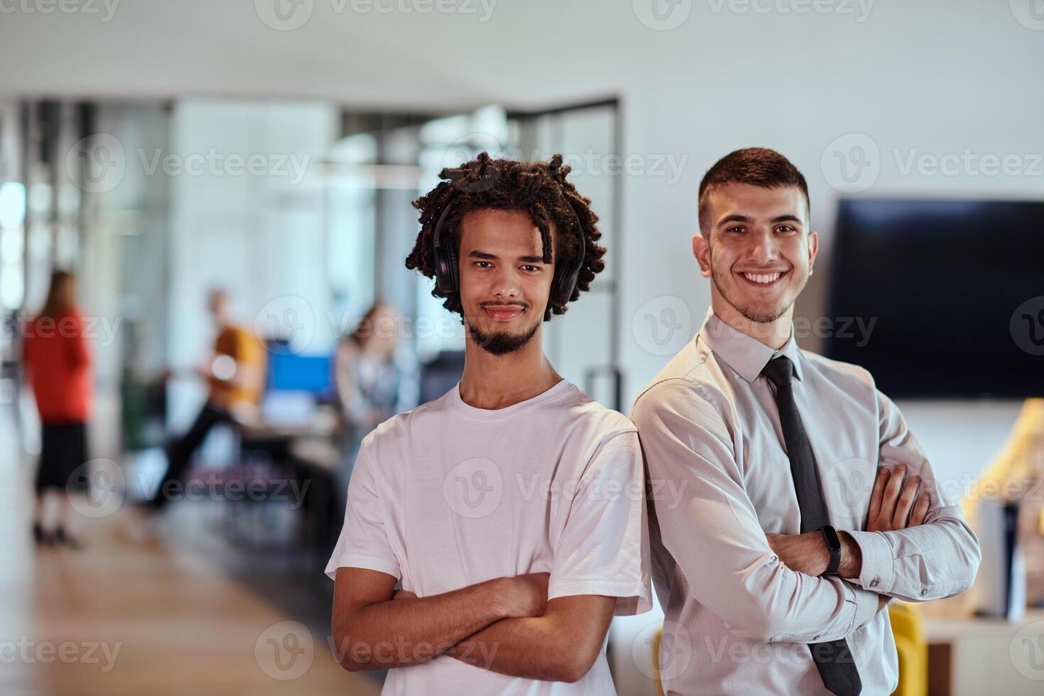A group of colleagues, including an African American businessman and a young leader in a shirt and tie, pose together in a modern coworking center office, representing a dynamic blend of photo