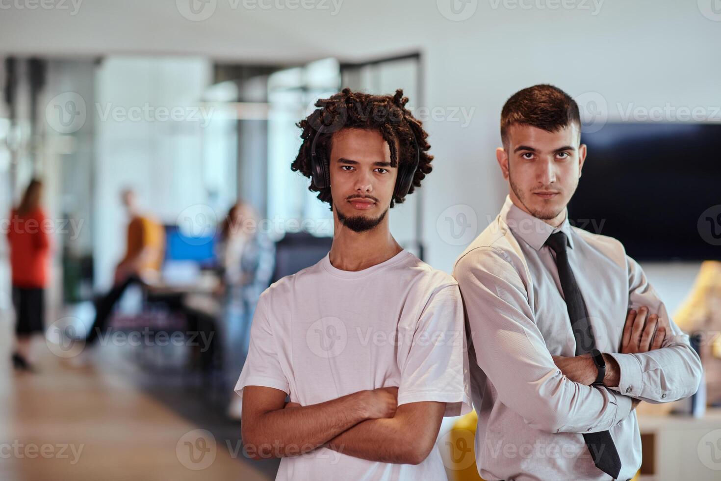 A group of colleagues, including an African American businessman and a young leader in a shirt and tie, pose together in a modern coworking center office, representing a dynamic blend of photo
