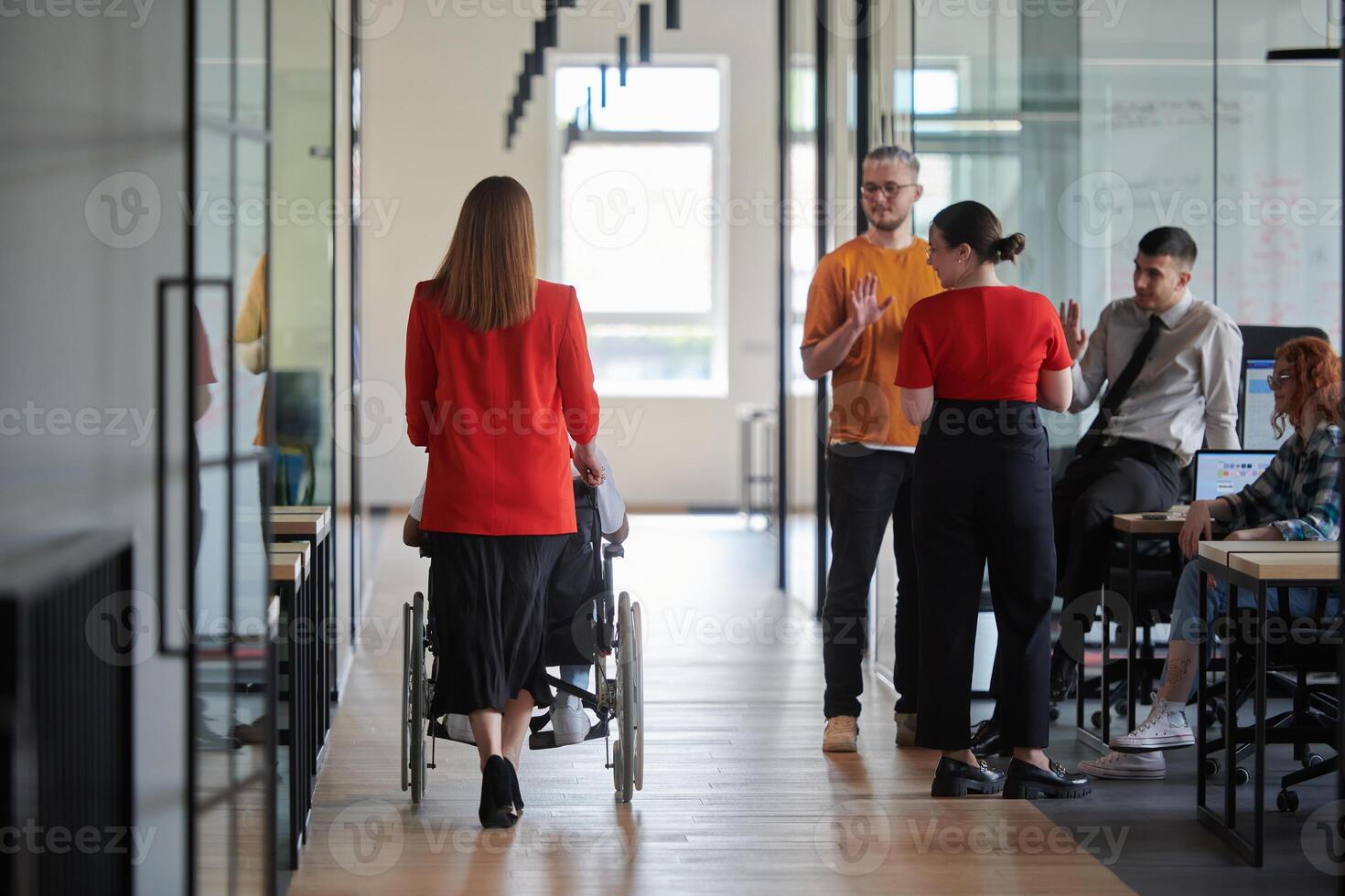 A group of young business people in a modern glass-walled office captures the essence of diversity and collaboration, while two colleagues, including an African American businessman in a wheelchair photo
