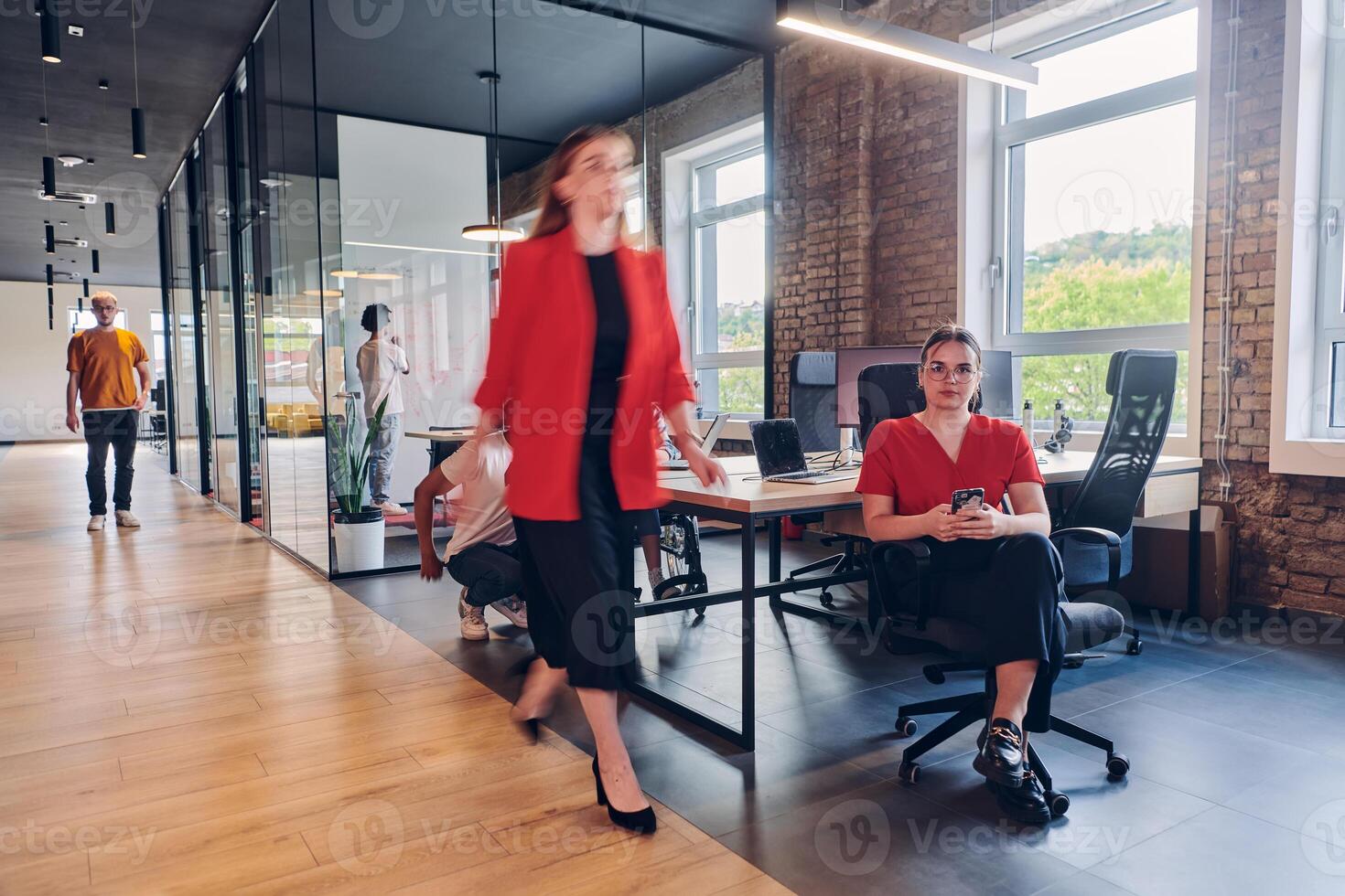 A diverse group of business professionals collaborates in a modern startup coworking center, utilizing a mix of paper-based and technological tools such as mobile phones and computers to collectively photo