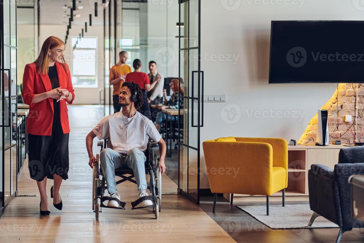 A group of young business people in a modern glass-walled office captures the essence of diversity and collaboration, while two colleagues, including an African American businessman in a wheelchair photo
