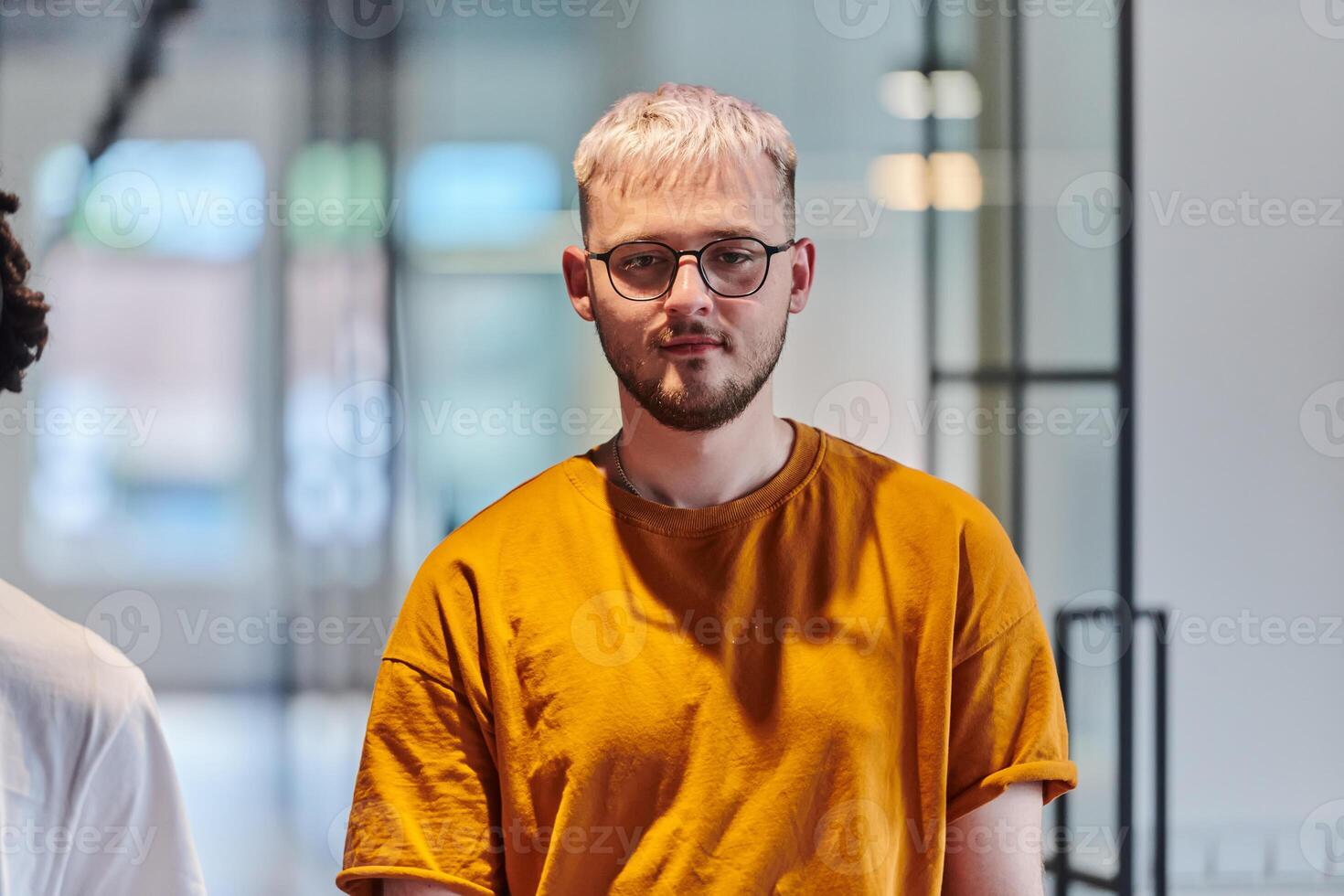 A modern portrait captures a blue-haired businessman wearing glasses, exuding creativity and professionalism, within the ambiance of a startup coworking office photo