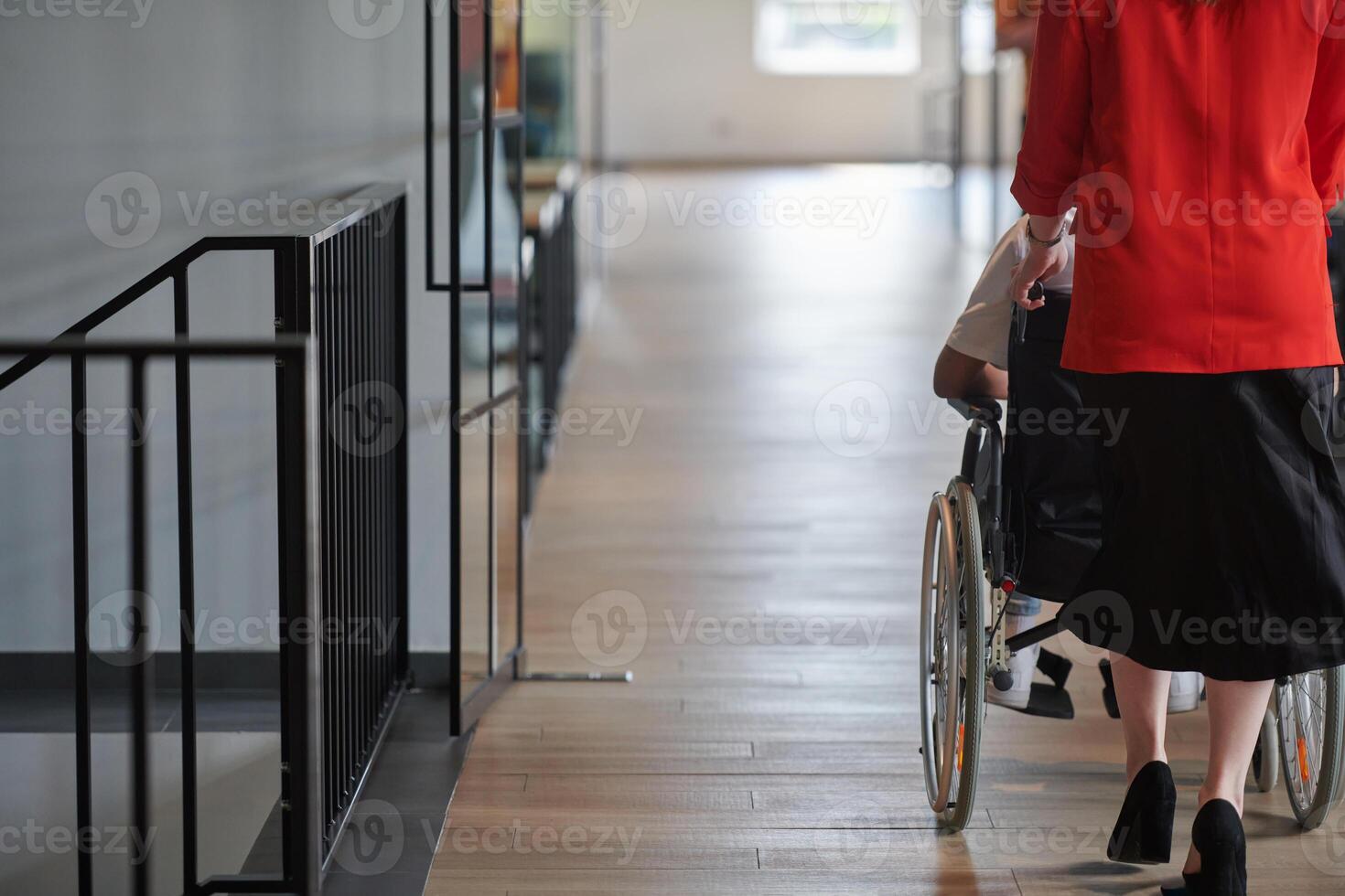 A group of young business people in a modern glass-walled office captures the essence of diversity and collaboration, while two colleagues, including an African American businessman in a wheelchair photo