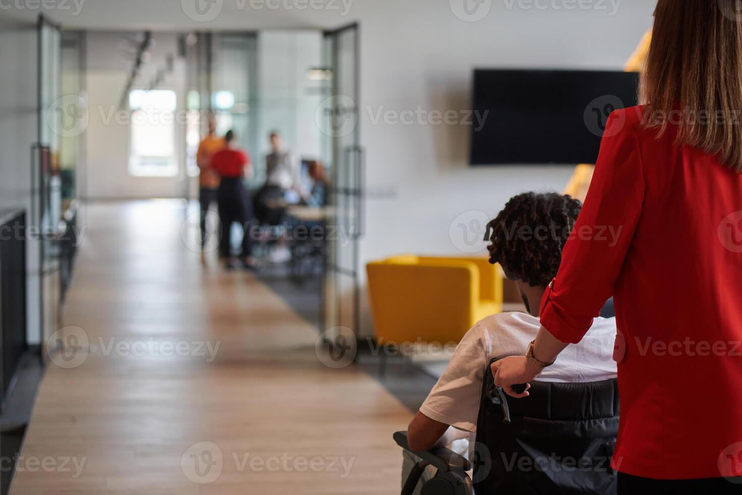A group of young business people in a modern glass-walled office captures the essence of diversity and collaboration, while two colleagues, including an African American businessman in a wheelchair photo