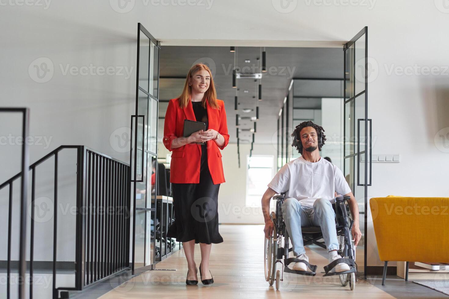 A group of young business people in a modern glass-walled office captures the essence of diversity and collaboration, while two colleagues, including an African American businessman in a wheelchair photo