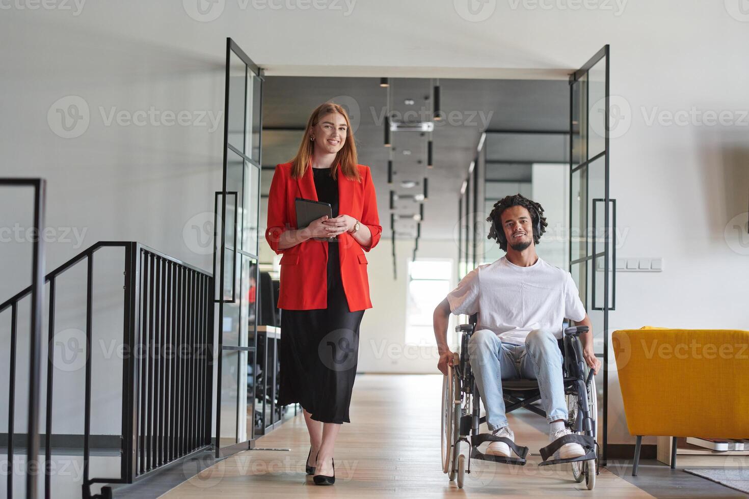 A group of young business people in a modern glass-walled office captures the essence of diversity and collaboration, while two colleagues, including an African American businessman in a wheelchair photo