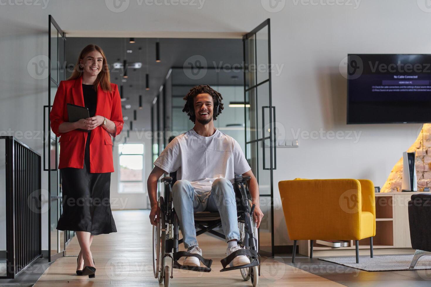 A group of young business people in a modern glass-walled office captures the essence of diversity and collaboration, while two colleagues, including an African American businessman in a wheelchair photo