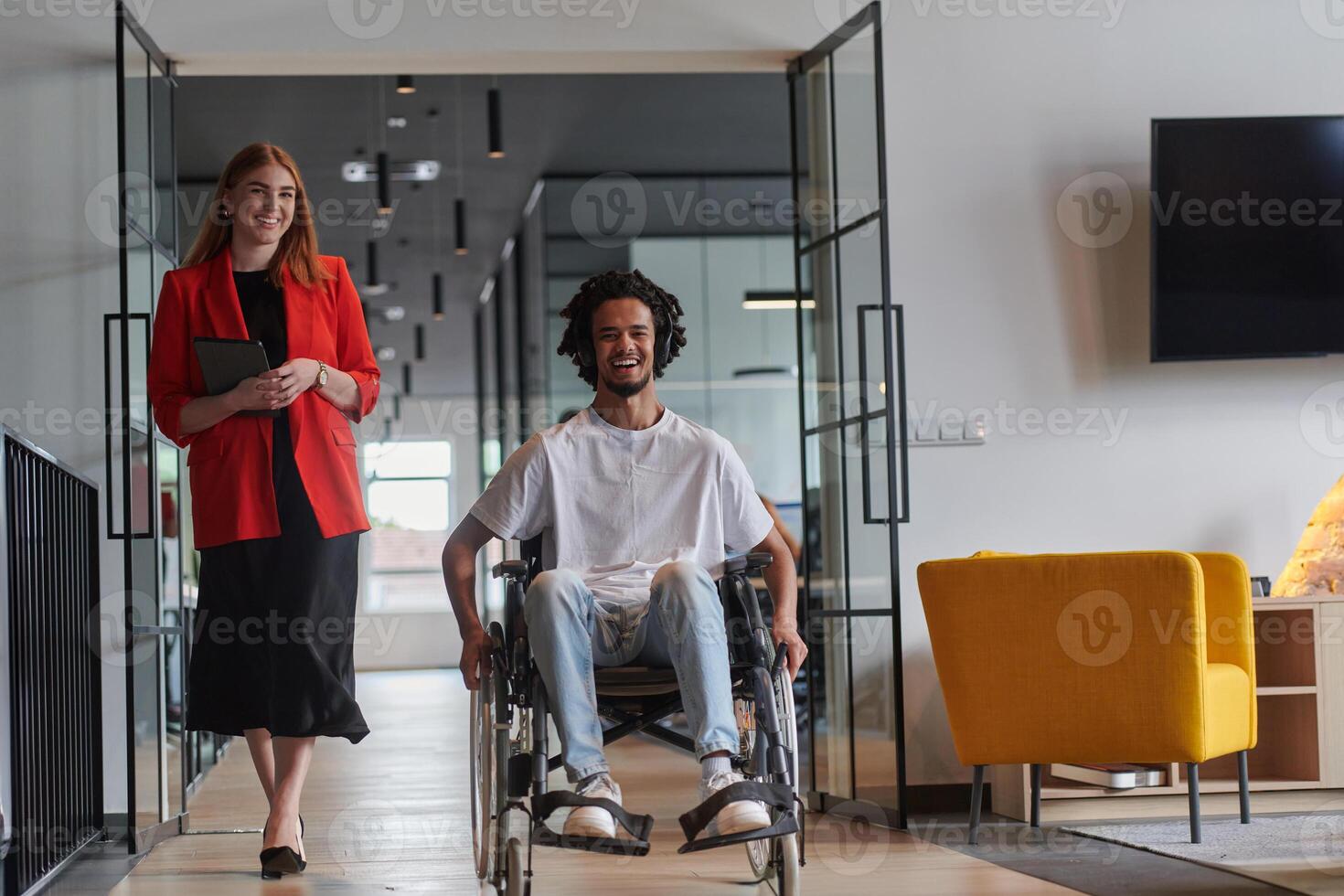 A group of young business people in a modern glass-walled office captures the essence of diversity and collaboration, while two colleagues, including an African American businessman in a wheelchair photo