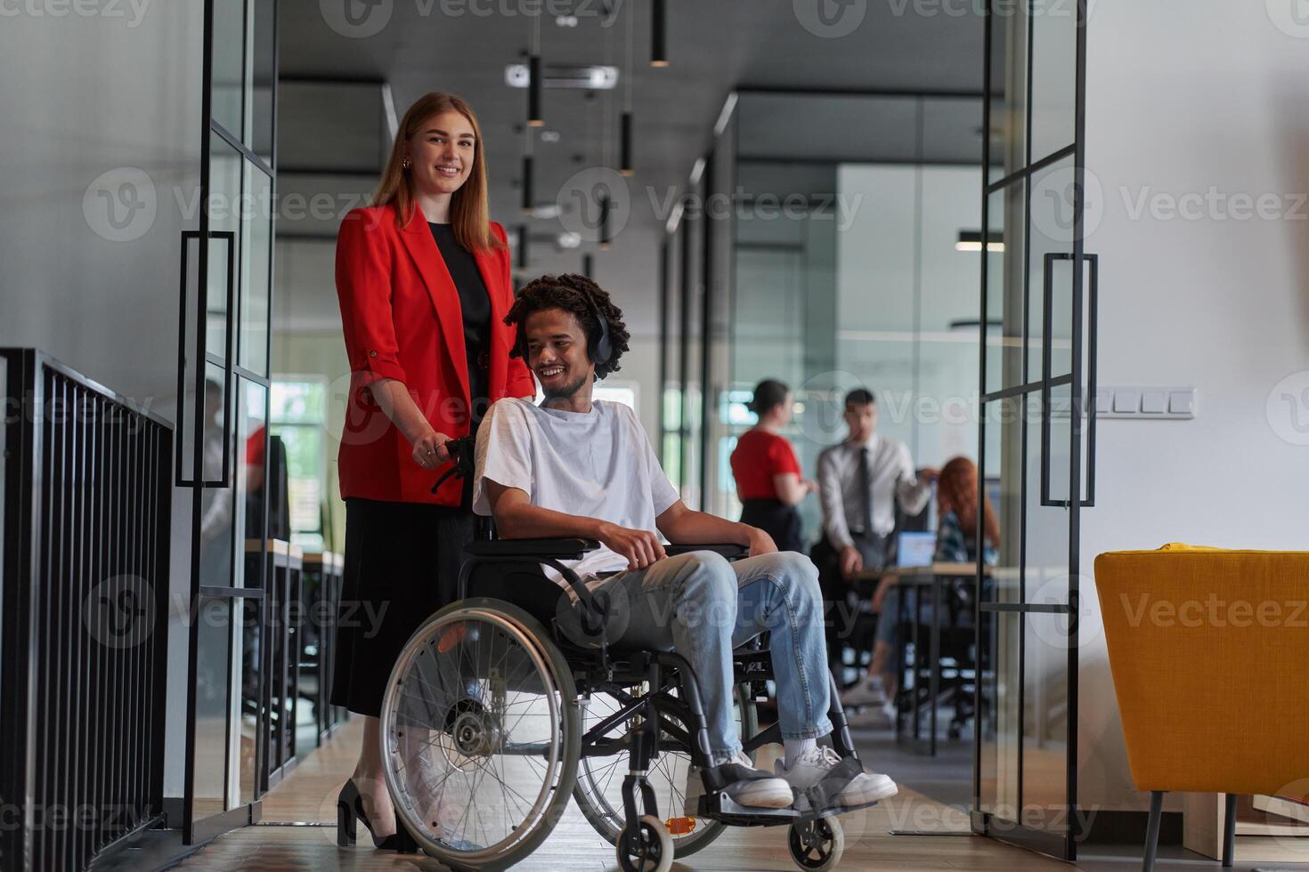 A group of young business people in a modern glass-walled office captures the essence of diversity and collaboration, while two colleagues, including an African American businessman in a wheelchair photo