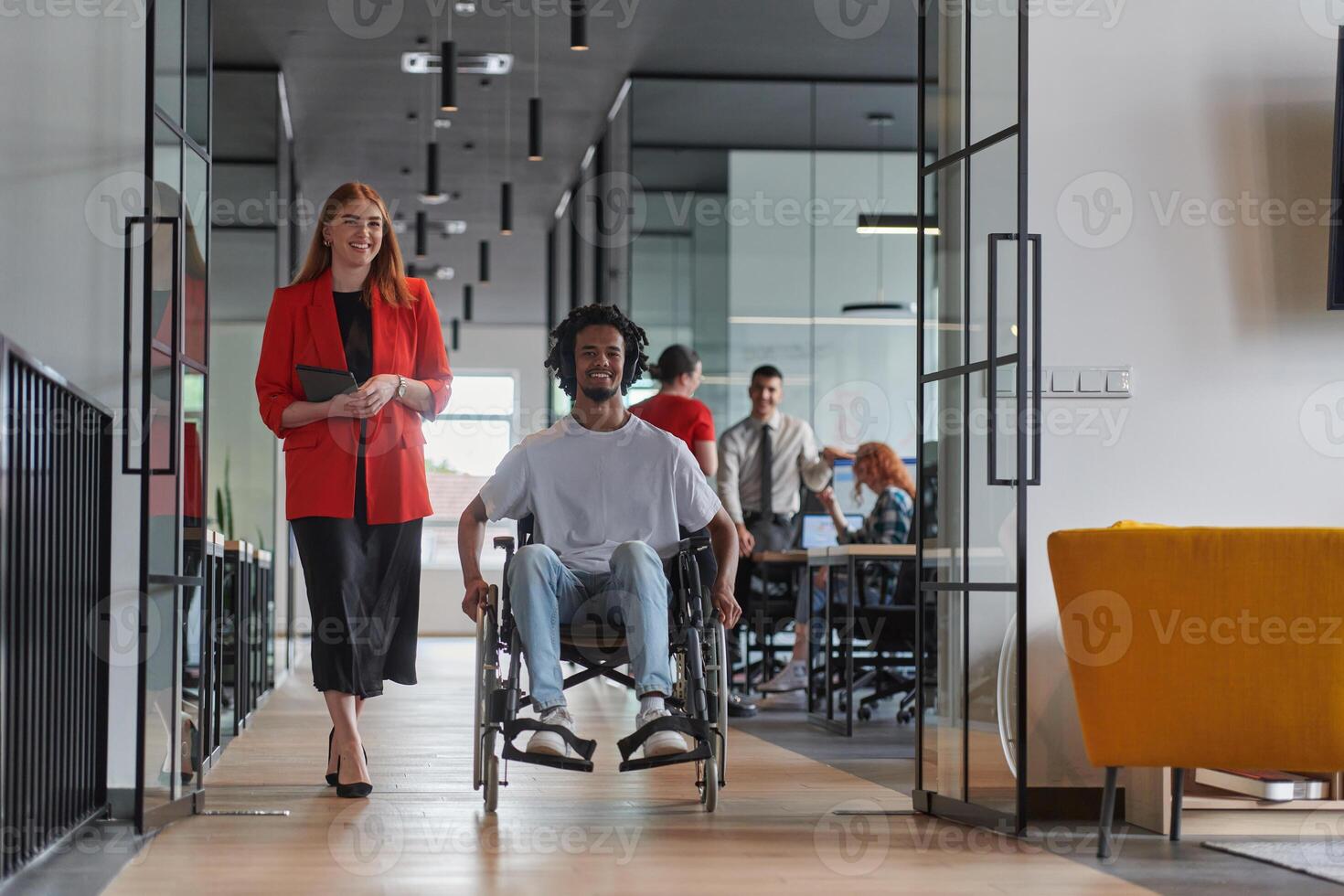 A group of young business people in a modern glass-walled office captures the essence of diversity and collaboration, while two colleagues, including an African American businessman in a wheelchair photo
