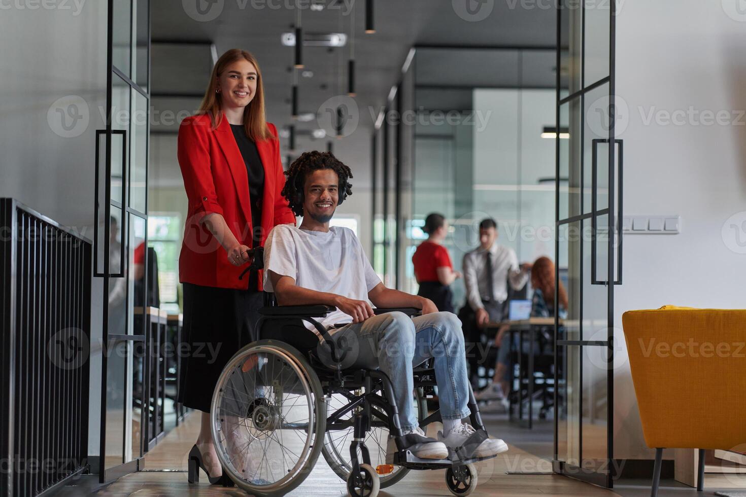 A group of young business people in a modern glass-walled office captures the essence of diversity and collaboration, while two colleagues, including an African American businessman in a wheelchair photo