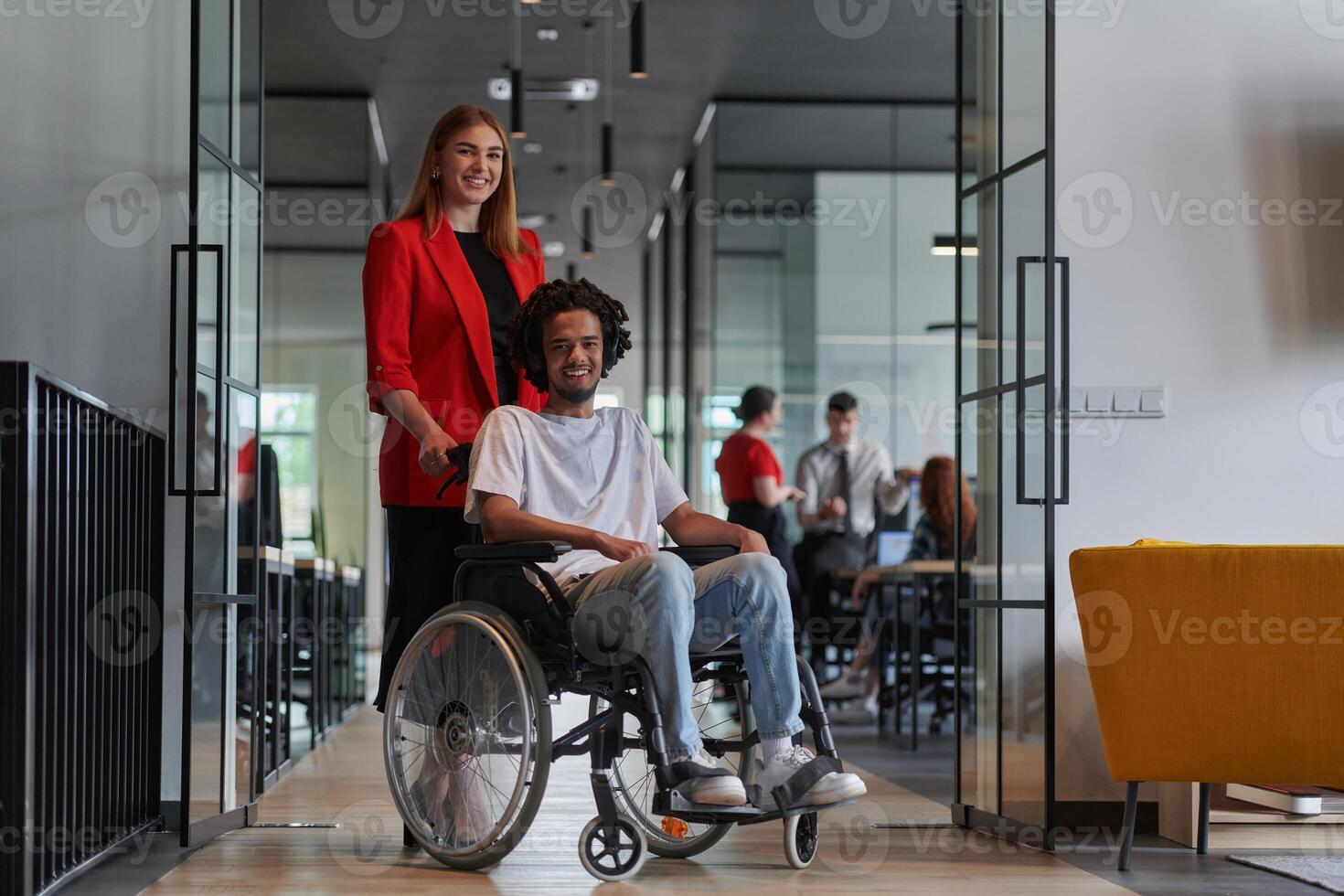 A group of young business people in a modern glass-walled office captures the essence of diversity and collaboration, while two colleagues, including an African American businessman in a wheelchair photo